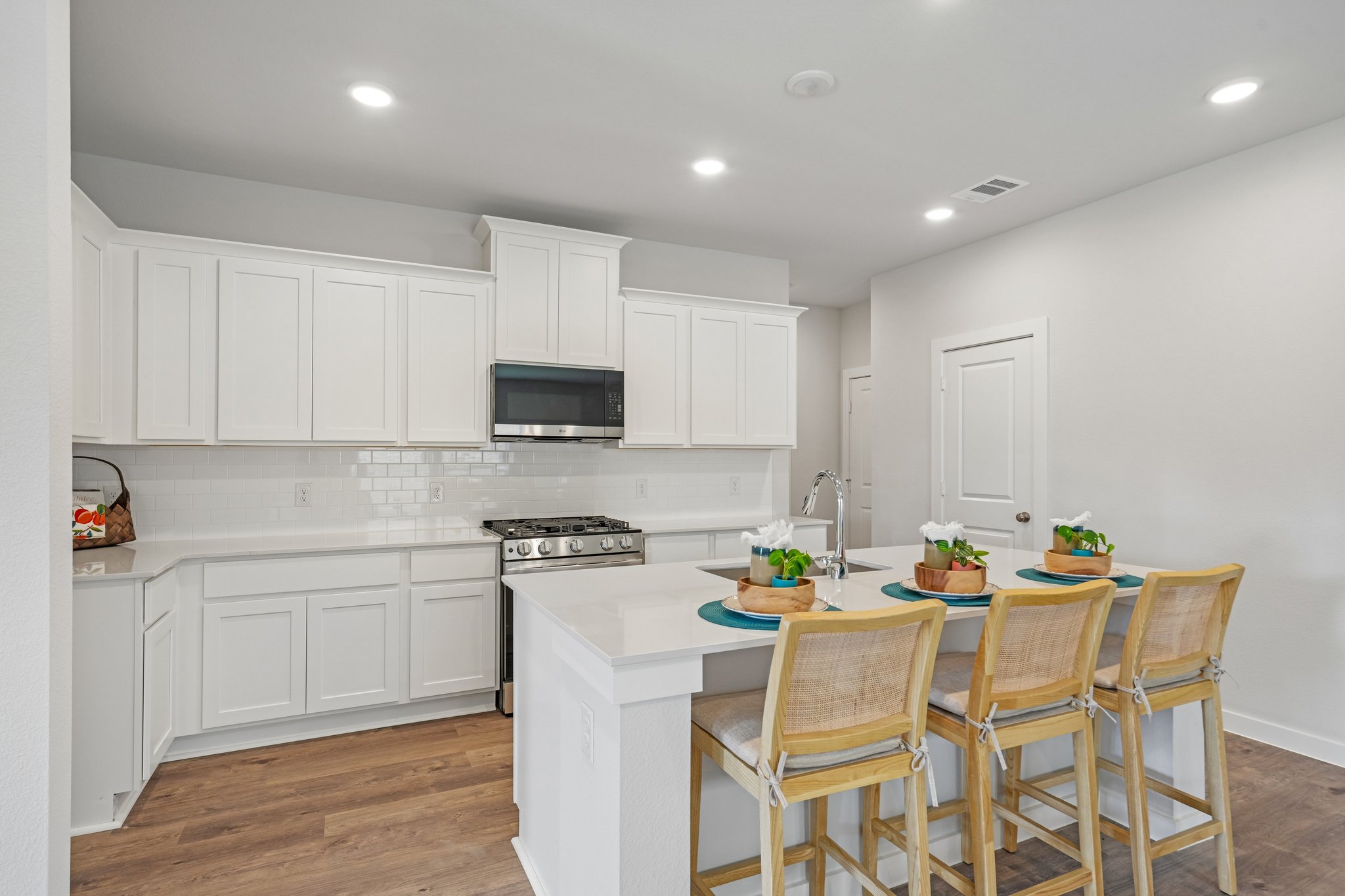 A kitchen with white cabinets.