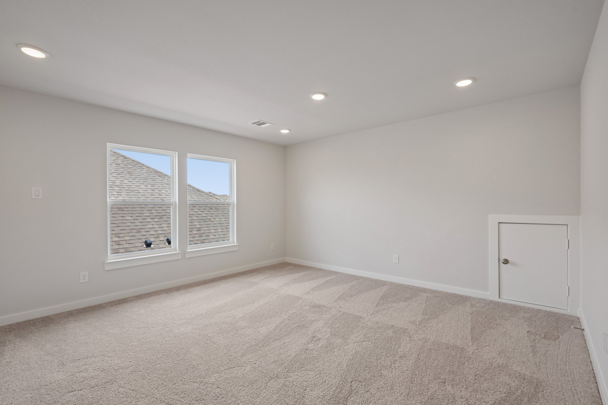 A room with a carpet and windows.