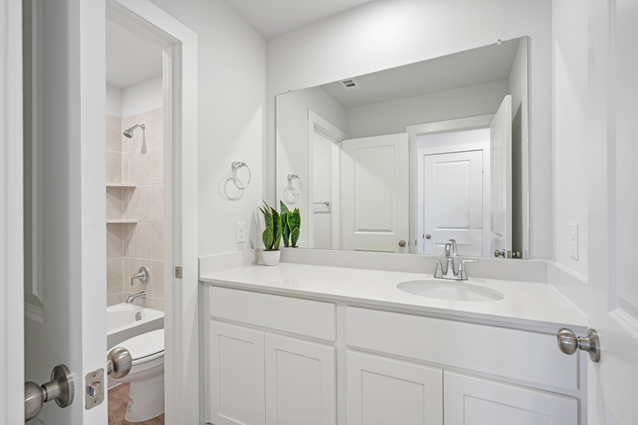 A bathroom with white cabinets.