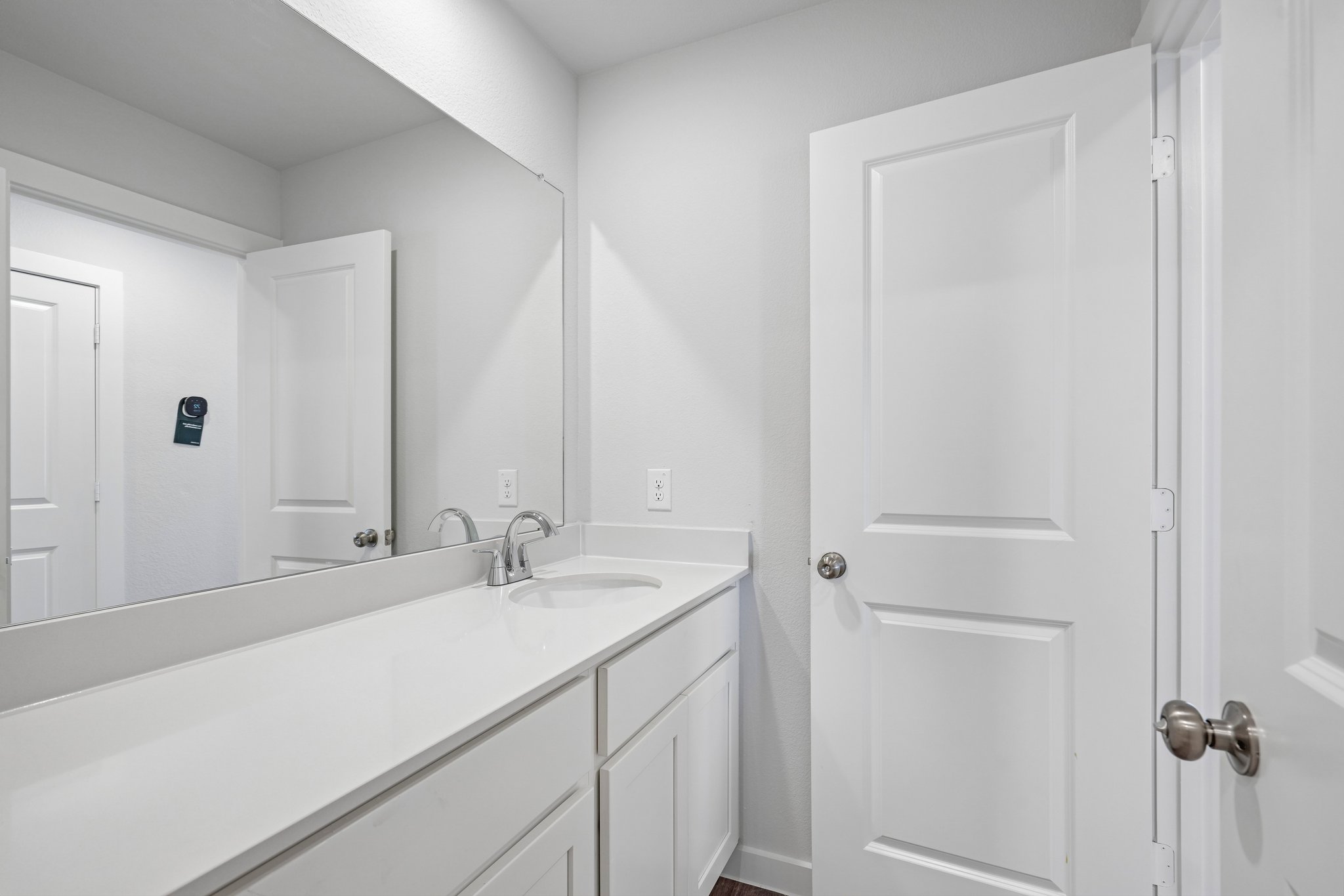 A bathroom with white cabinets.