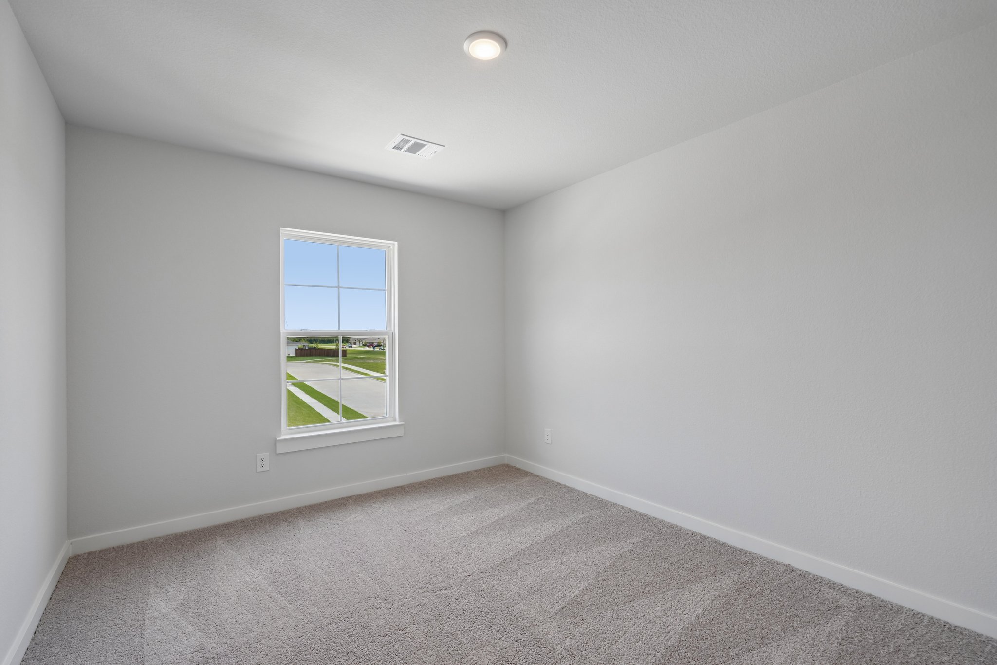 A room with a window and a carpet.