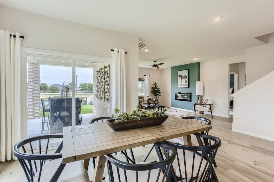 A dining room table with chairs and a large window.