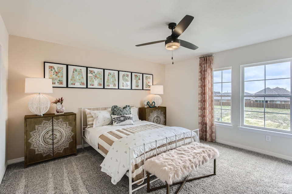 A bedroom with a bed and a fan.