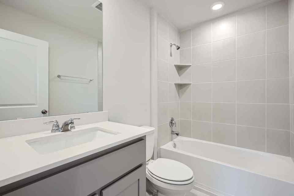 A bathroom with a tub sink and toilet.