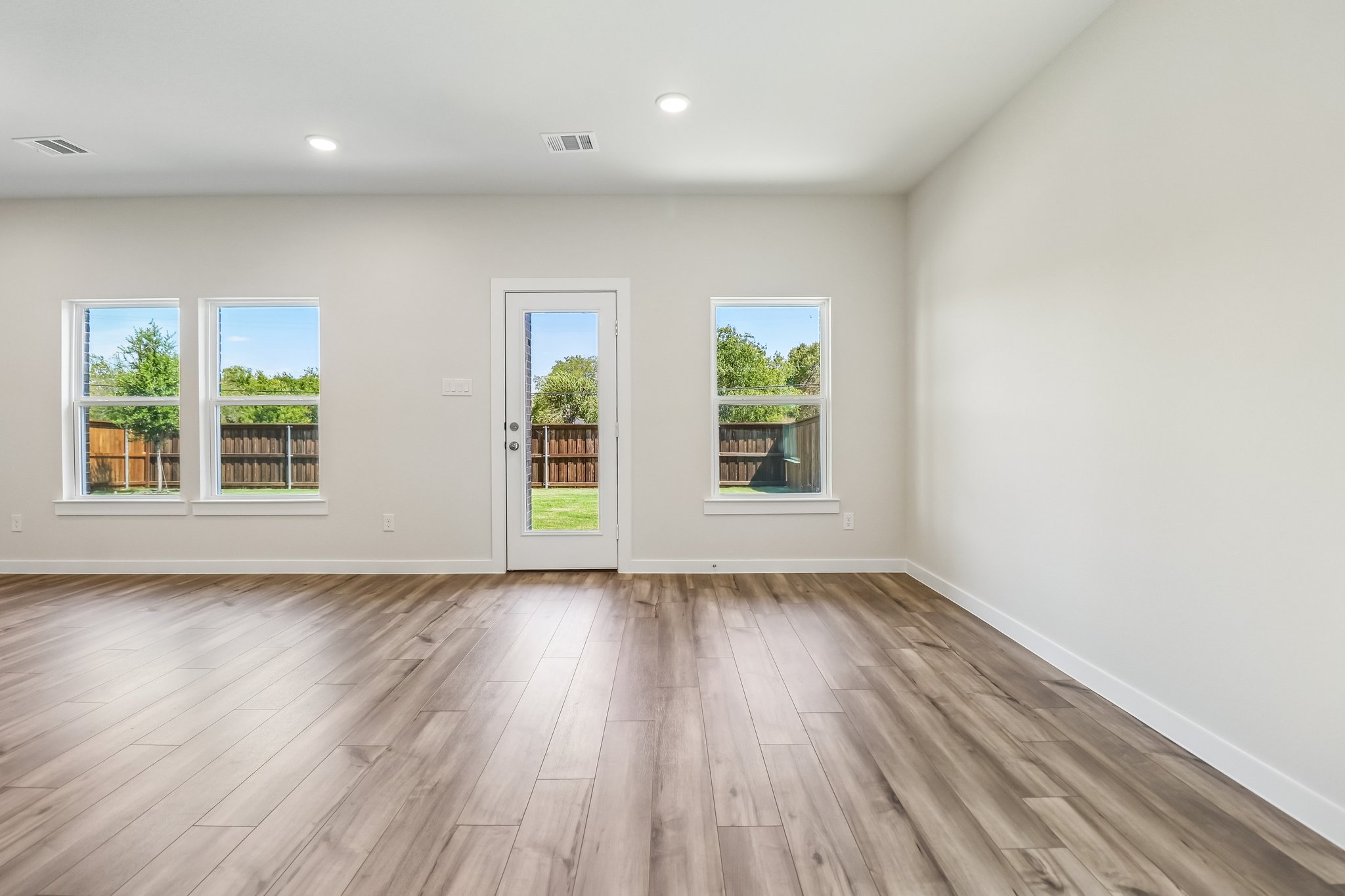 A room with windows and wood floors.