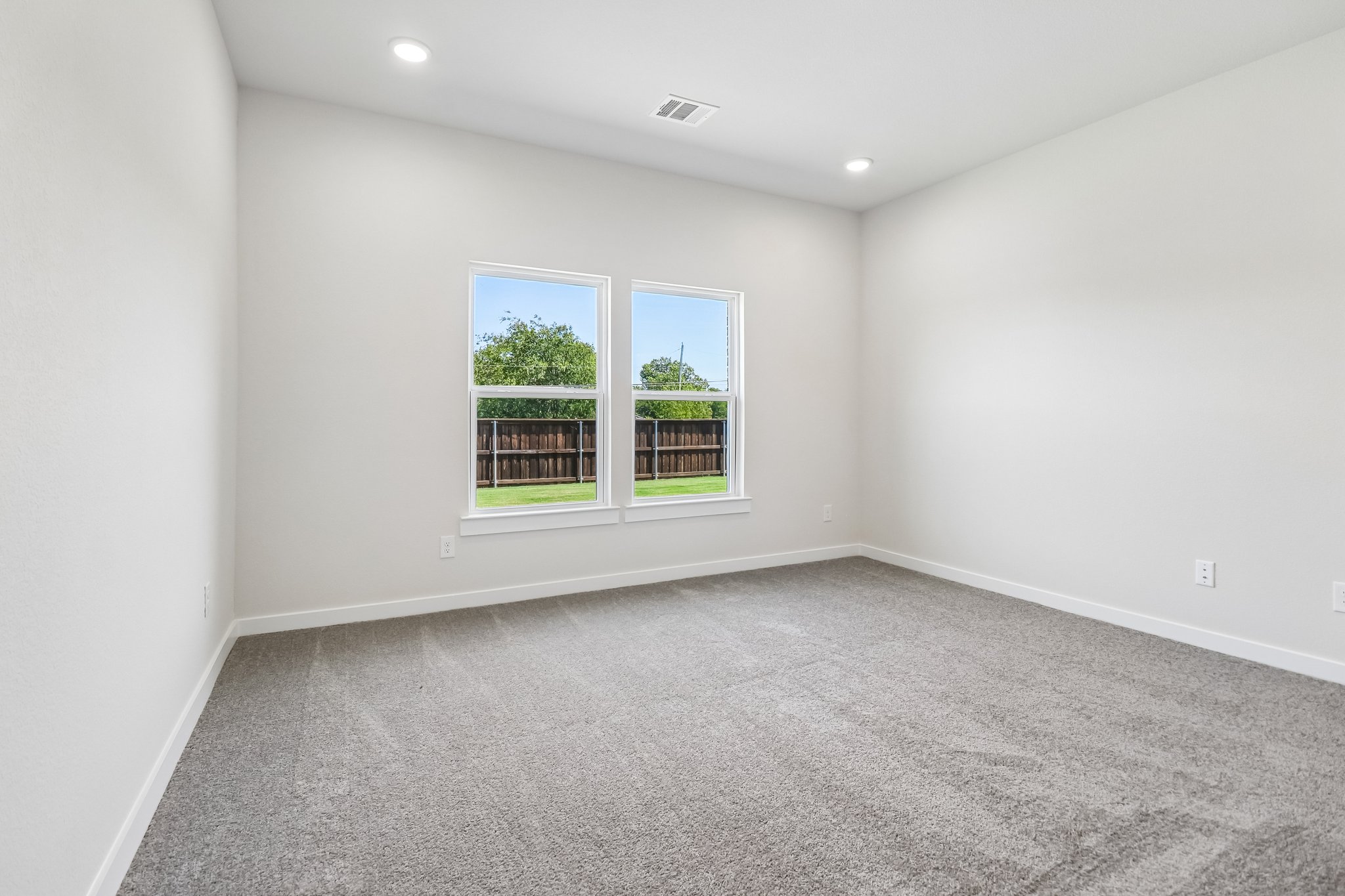 A room with a window and a carpet.