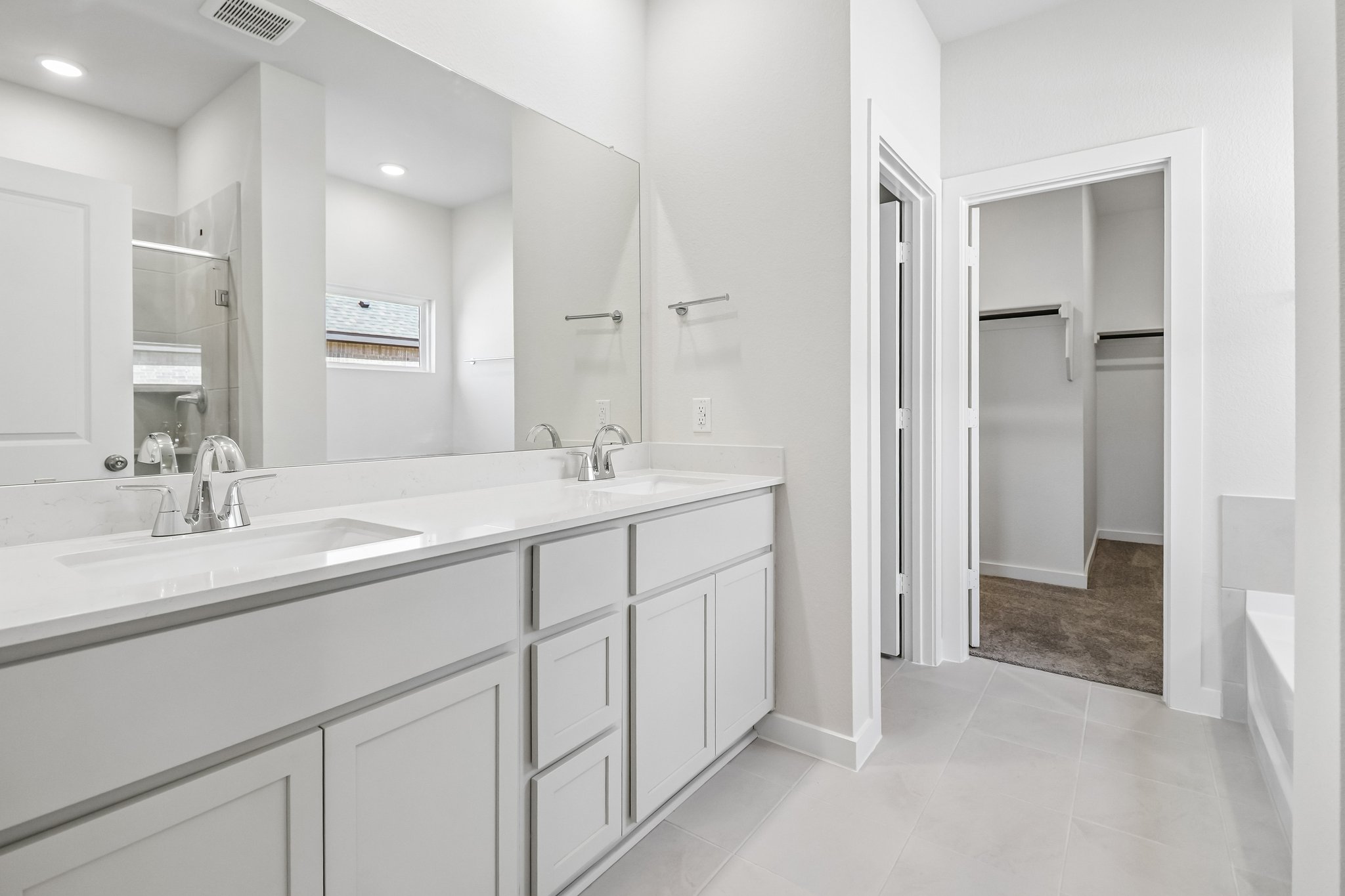 A bathroom with white cabinets.