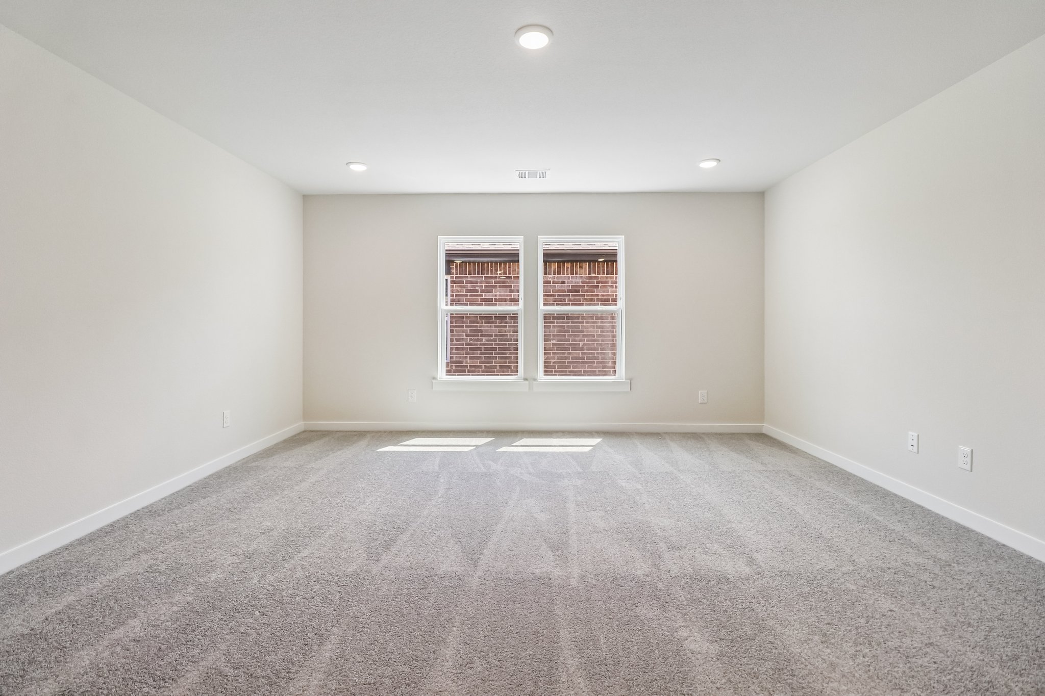 A room with a window and a carpet.