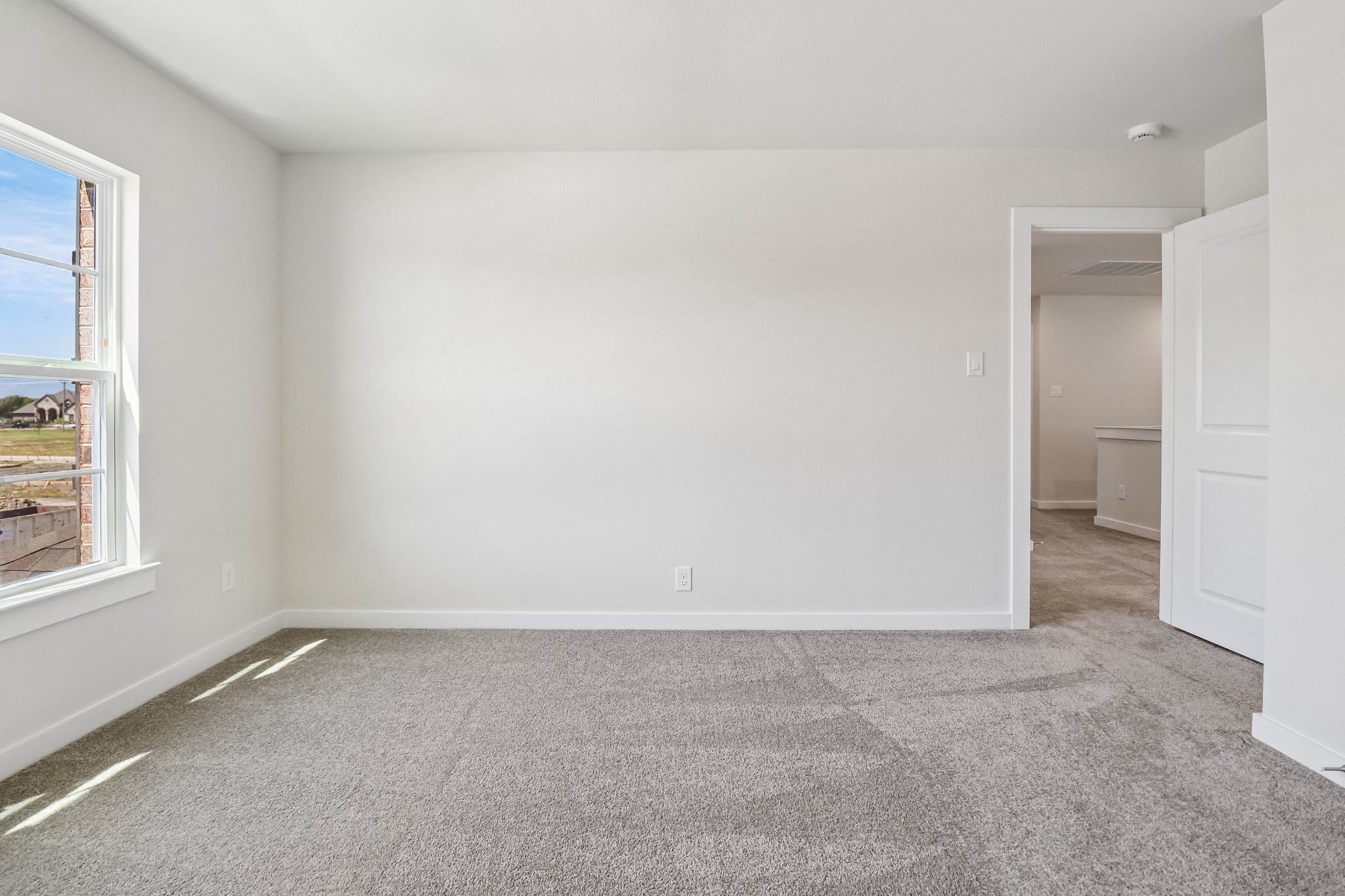 A room with a carpet and a window.