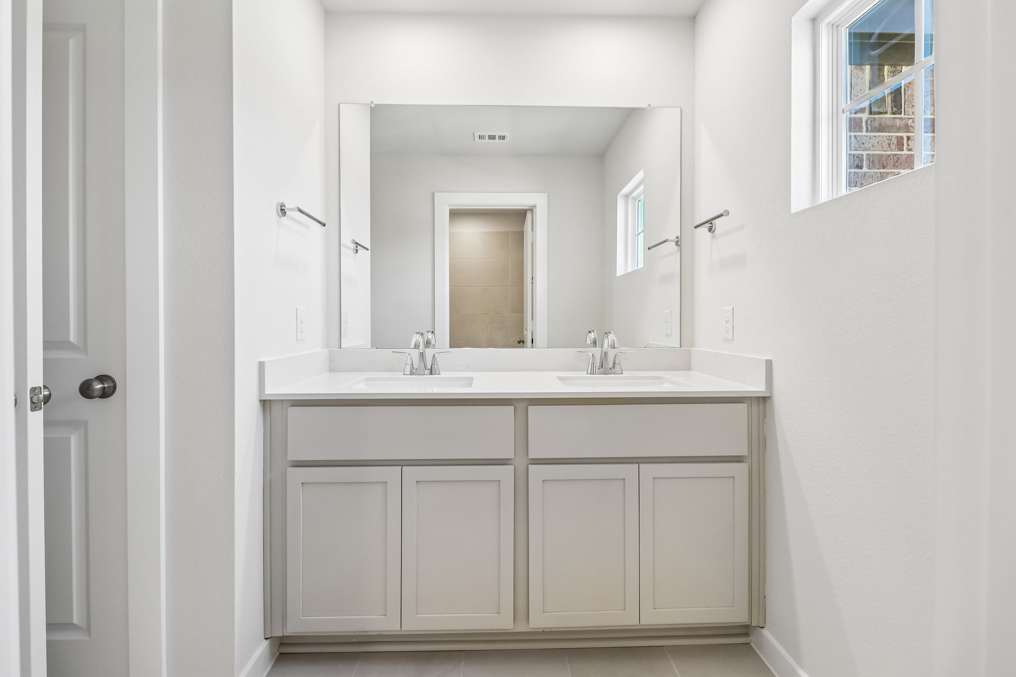 A bathroom with white cabinets.