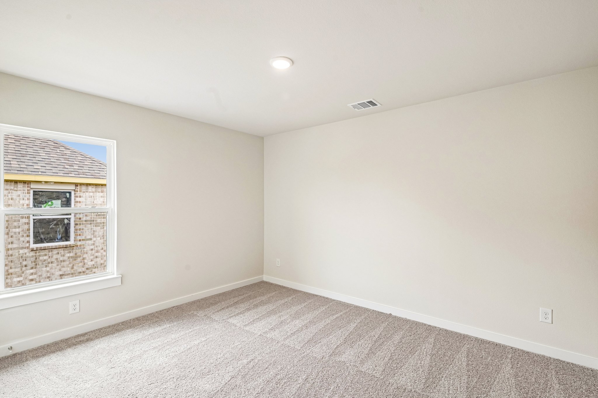 A room with a window and a carpet.