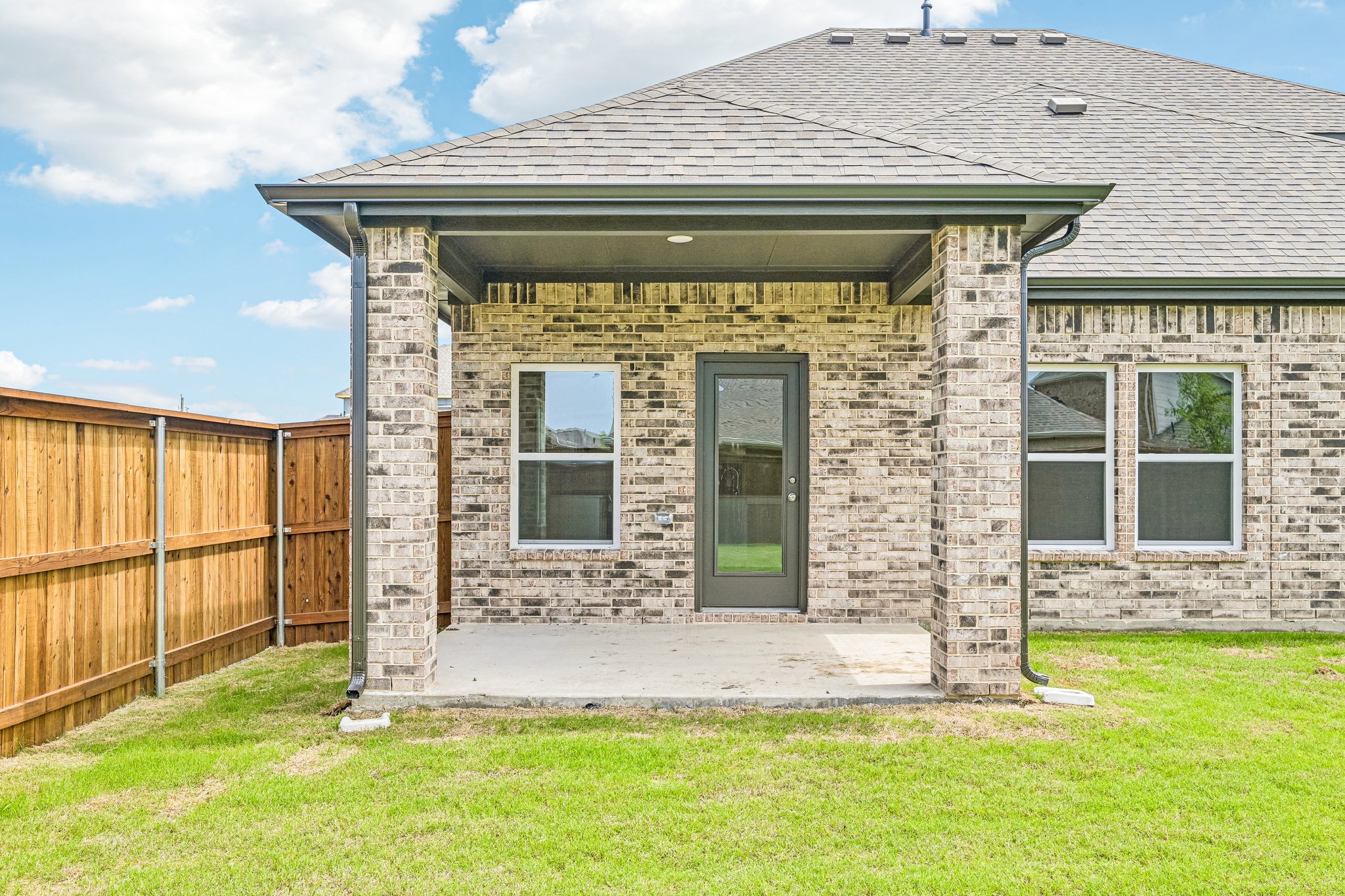 A brick house with a fence.