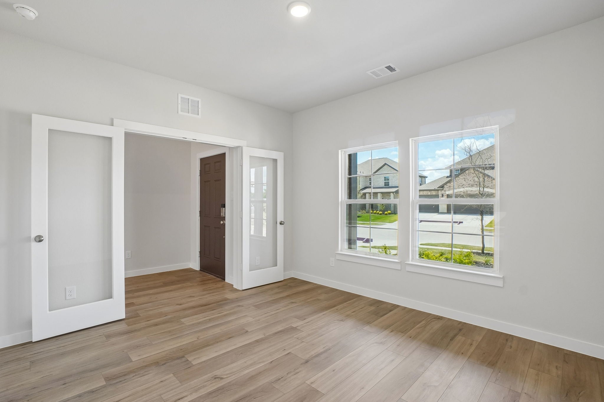 A room with a wood floor and a window with a wood floor.
