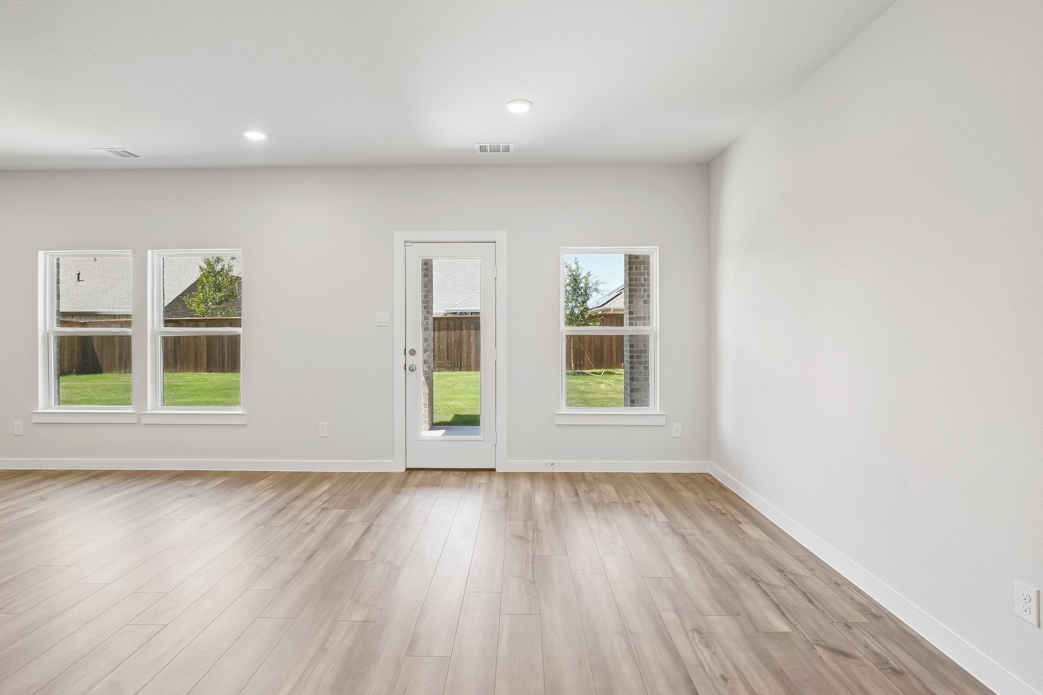 A room with windows and wood floors.