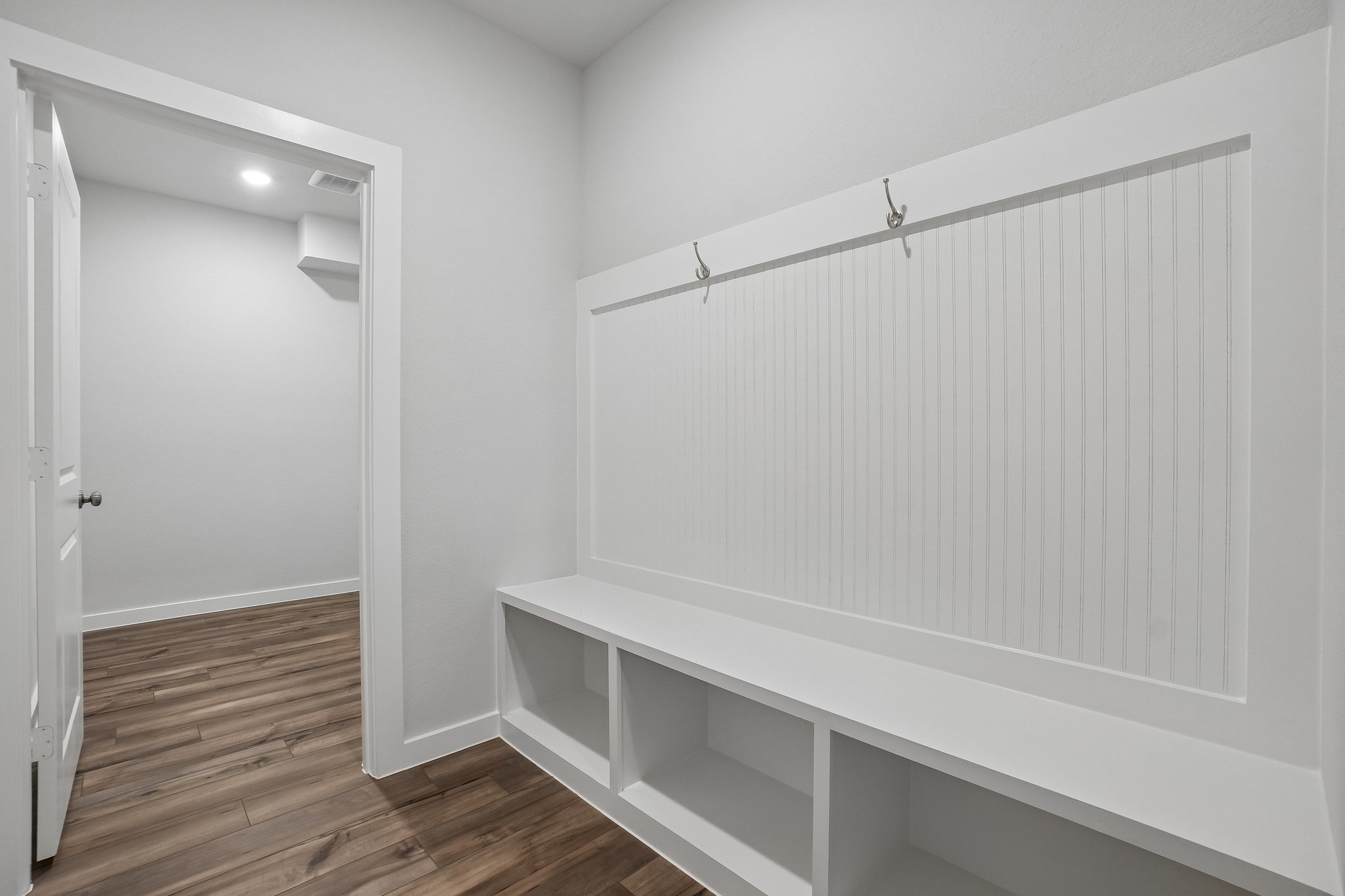 A white wall with a white bench.