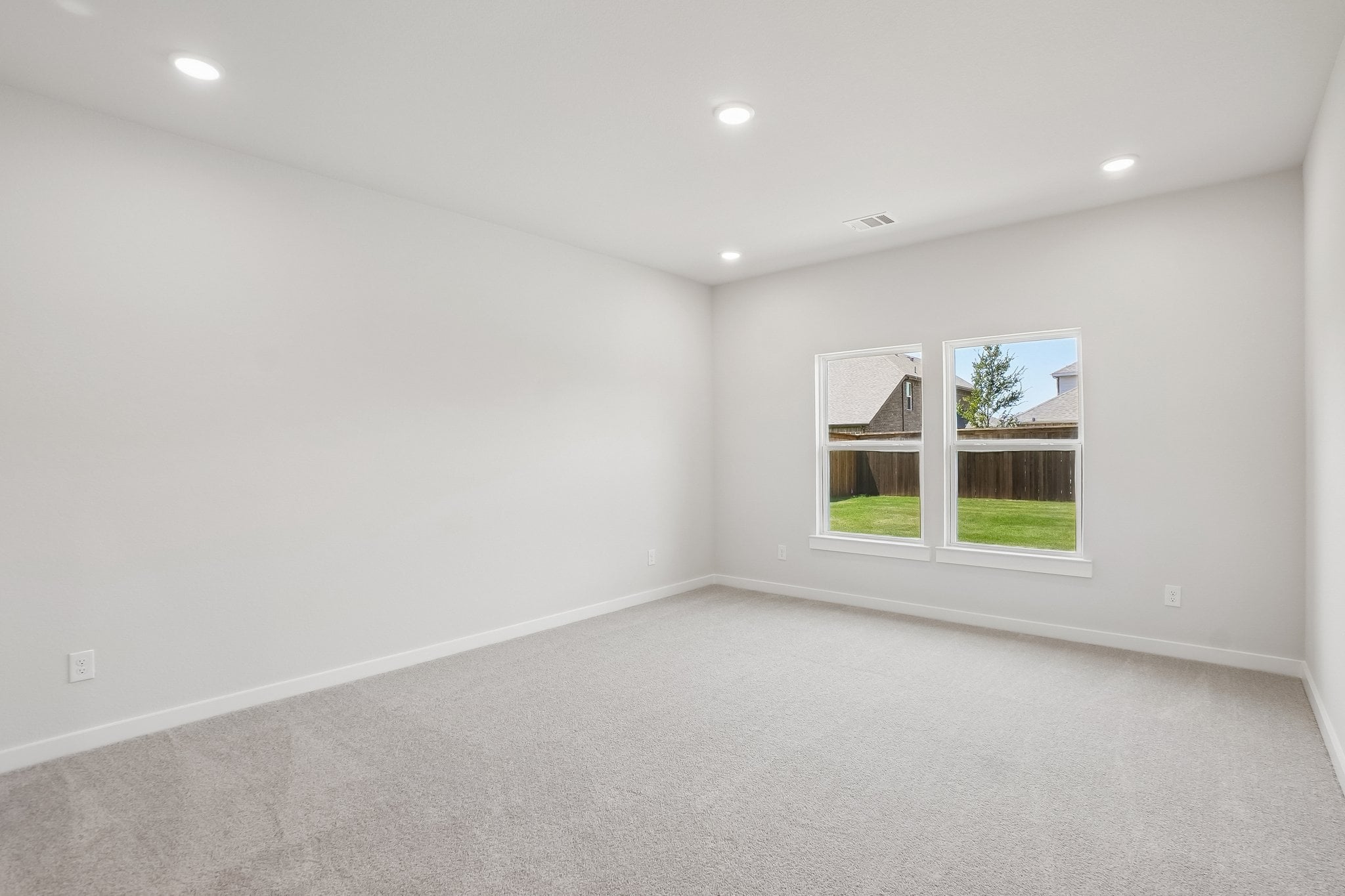 A room with a window and a white wall.