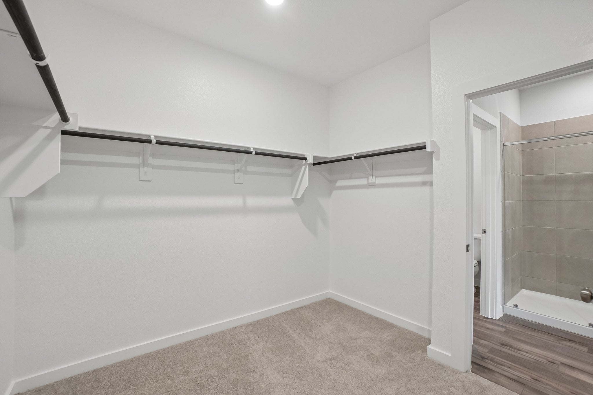 A white room with a shower and a glass door.