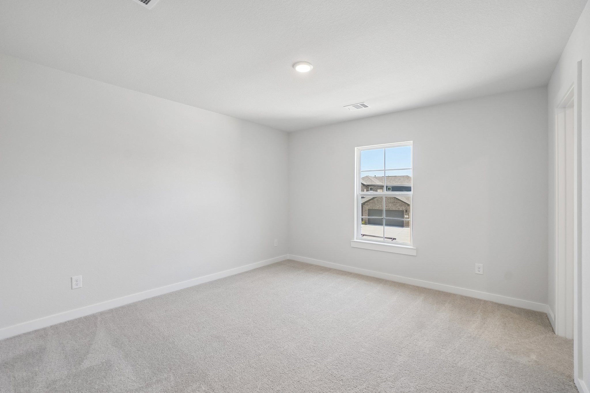 A room with a window and a carpet.
