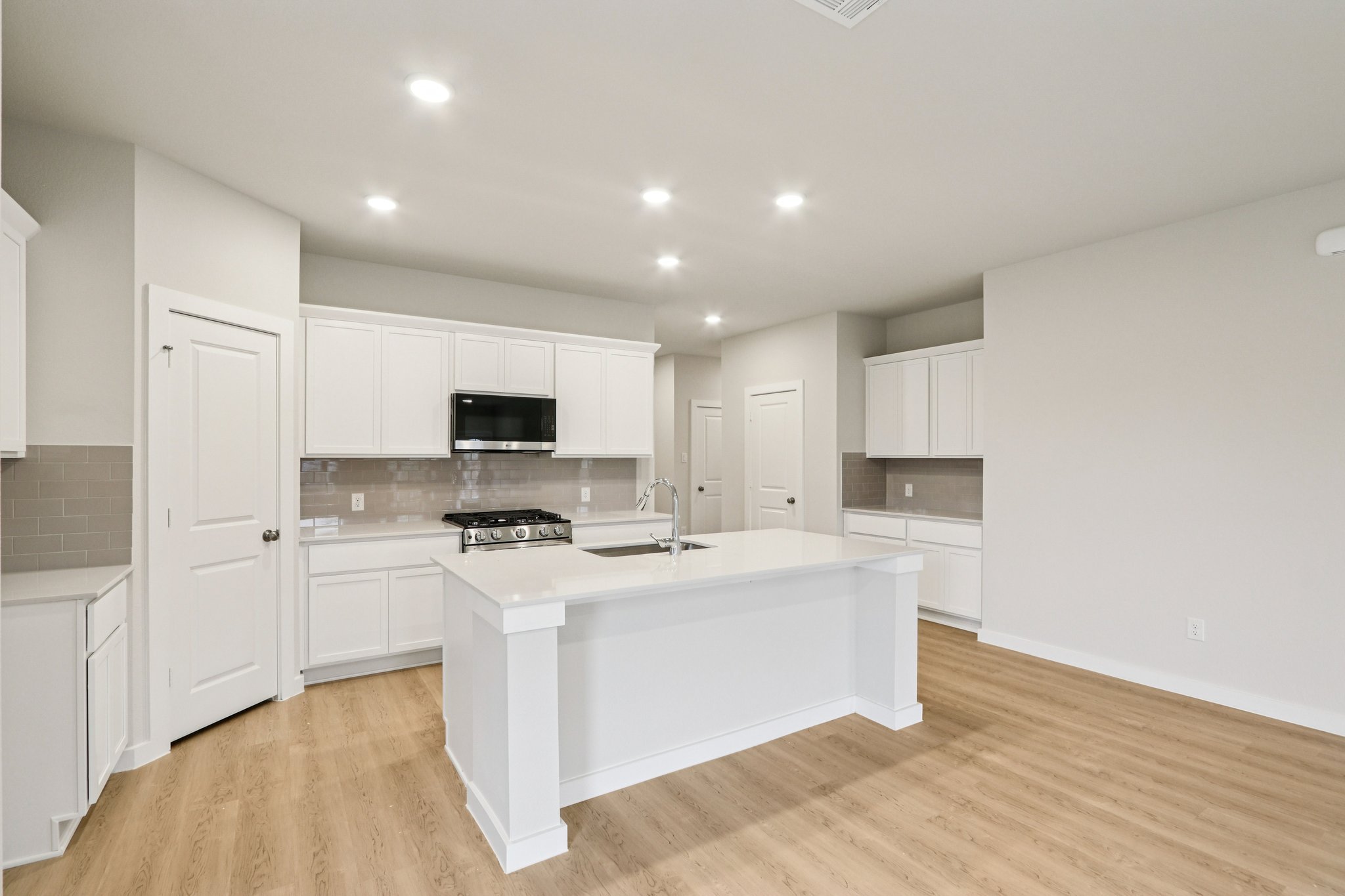 A kitchen with white cabinets.