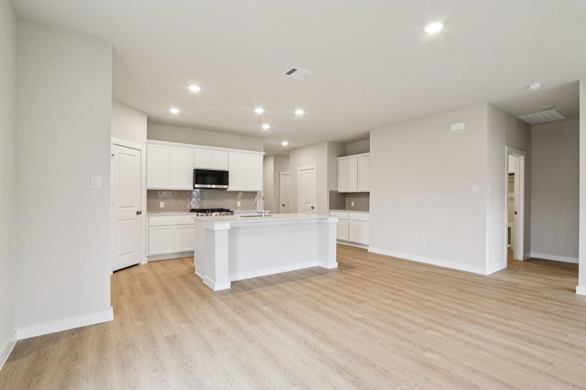 A kitchen with white cabinets.