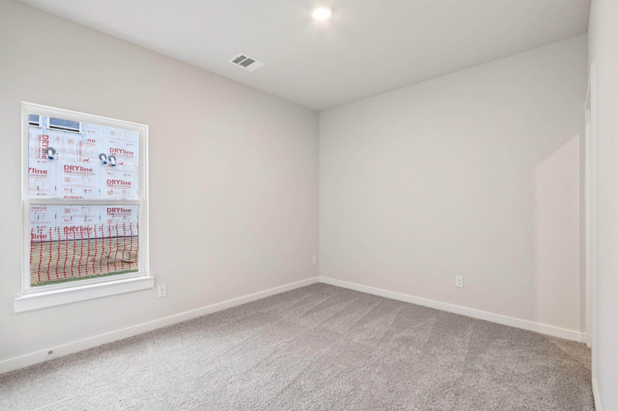 A room with a window and carpet.