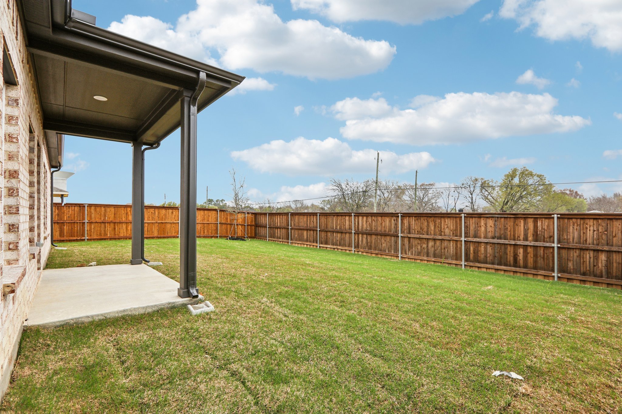 A fenced in yard with a wood building and a wood fence.