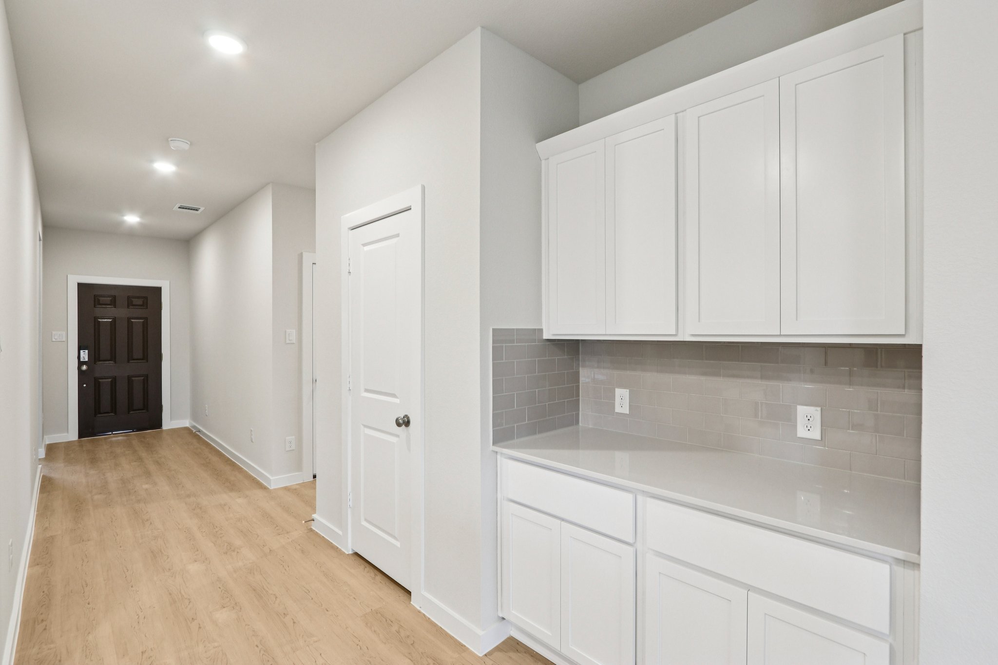 A kitchen with white cabinets.