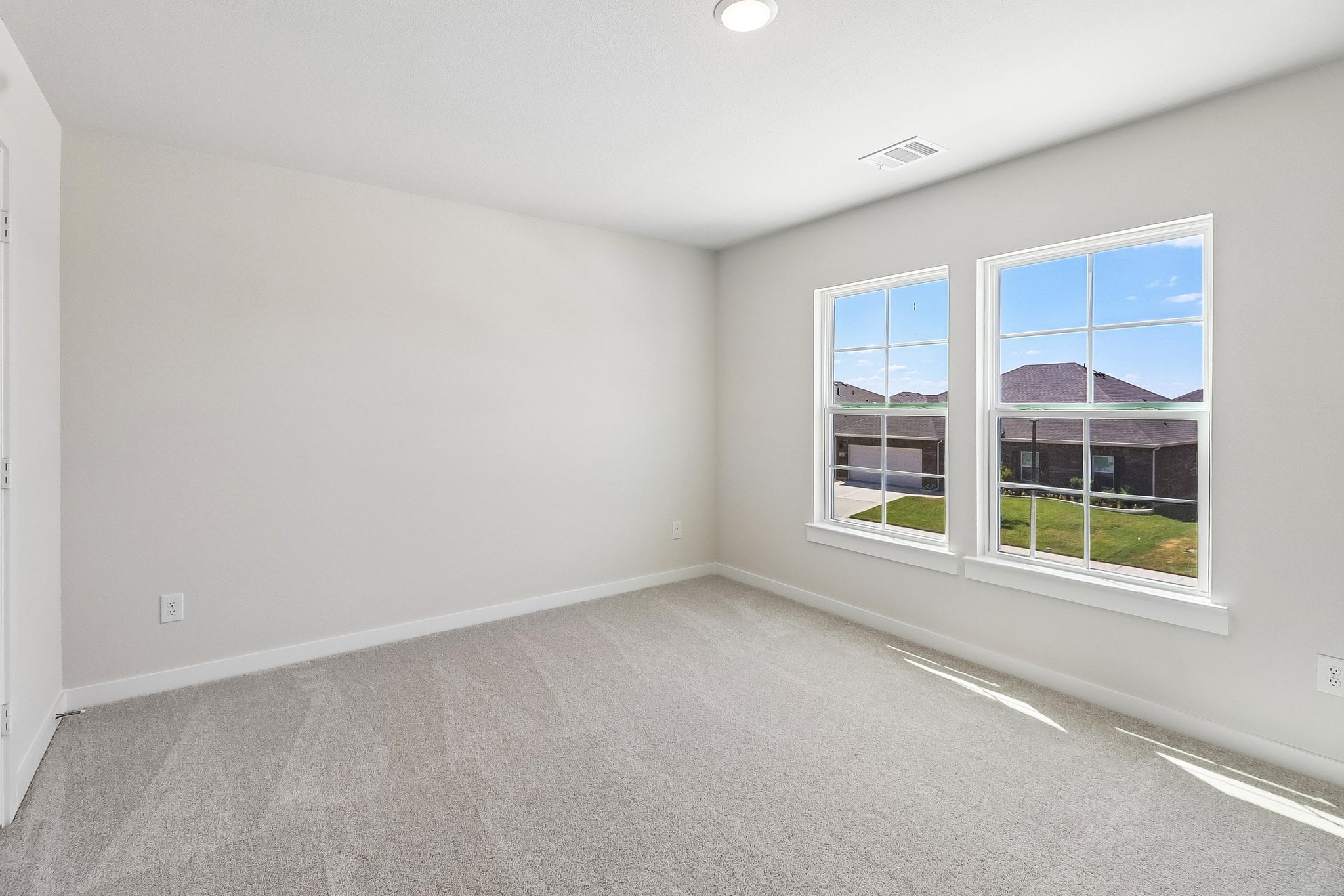 A room with a window and a white wall.