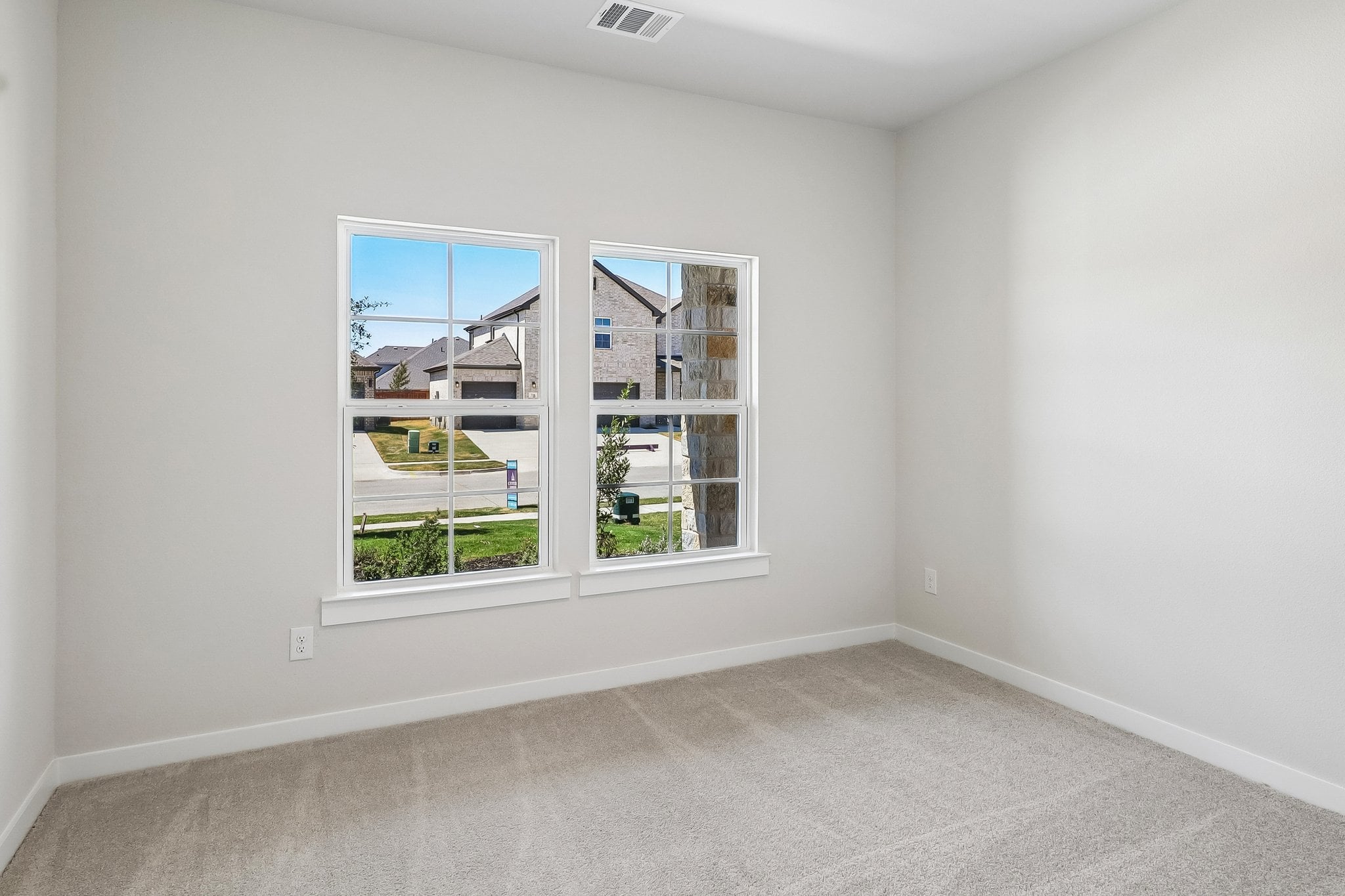 A room with a window and a white wall.