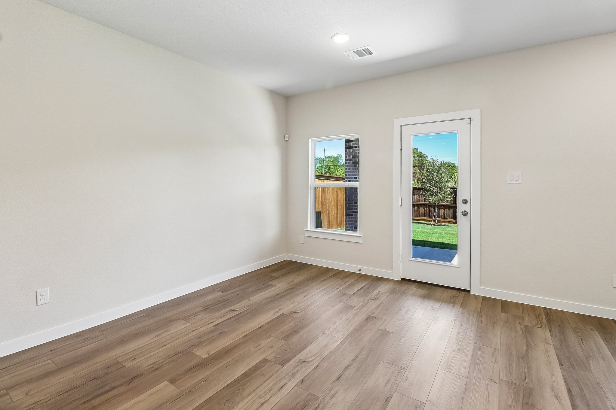 A room with a wood floor and a wood floor with a window.