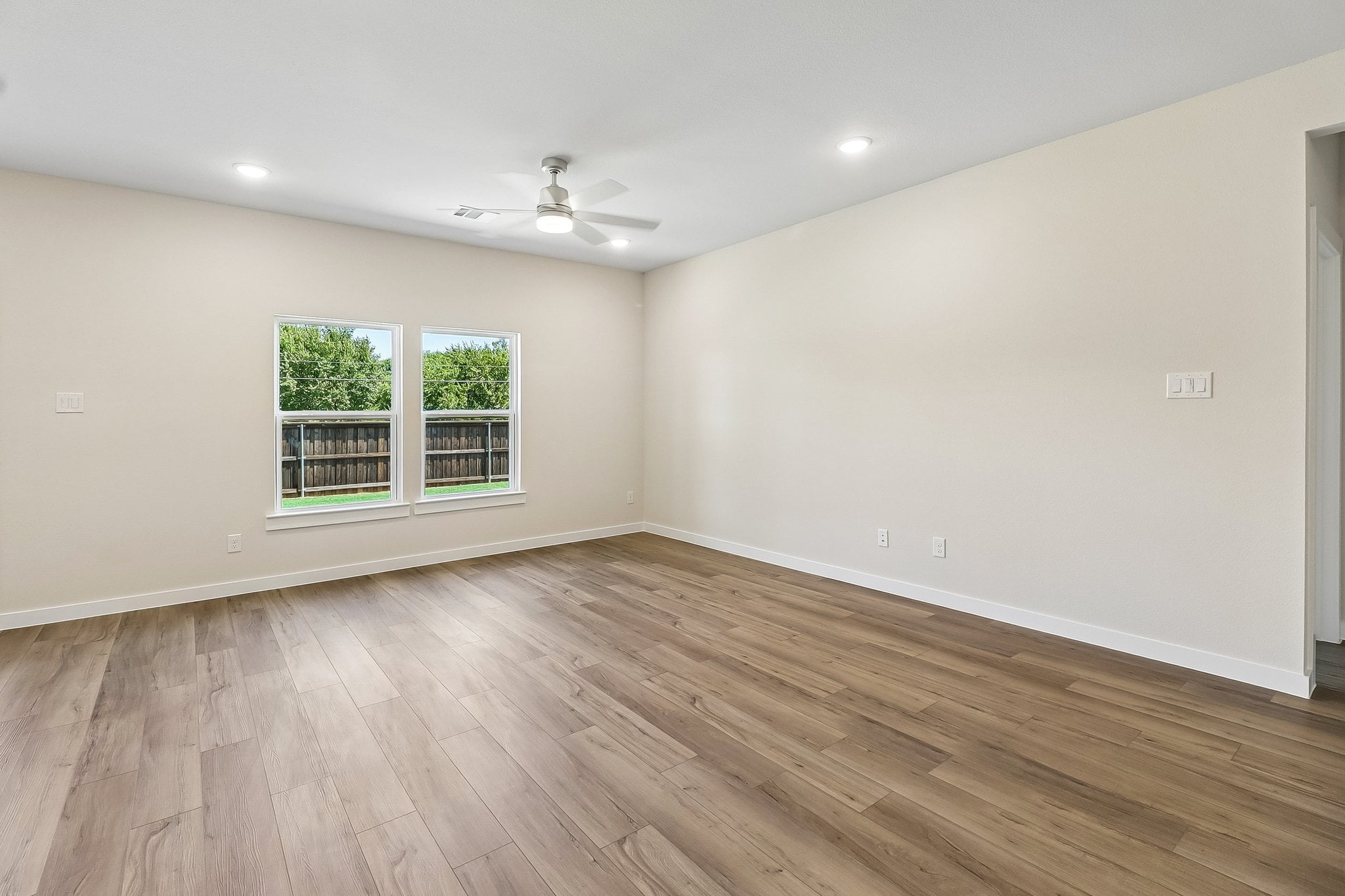 A room with a wood floor and a wood floor with a window.