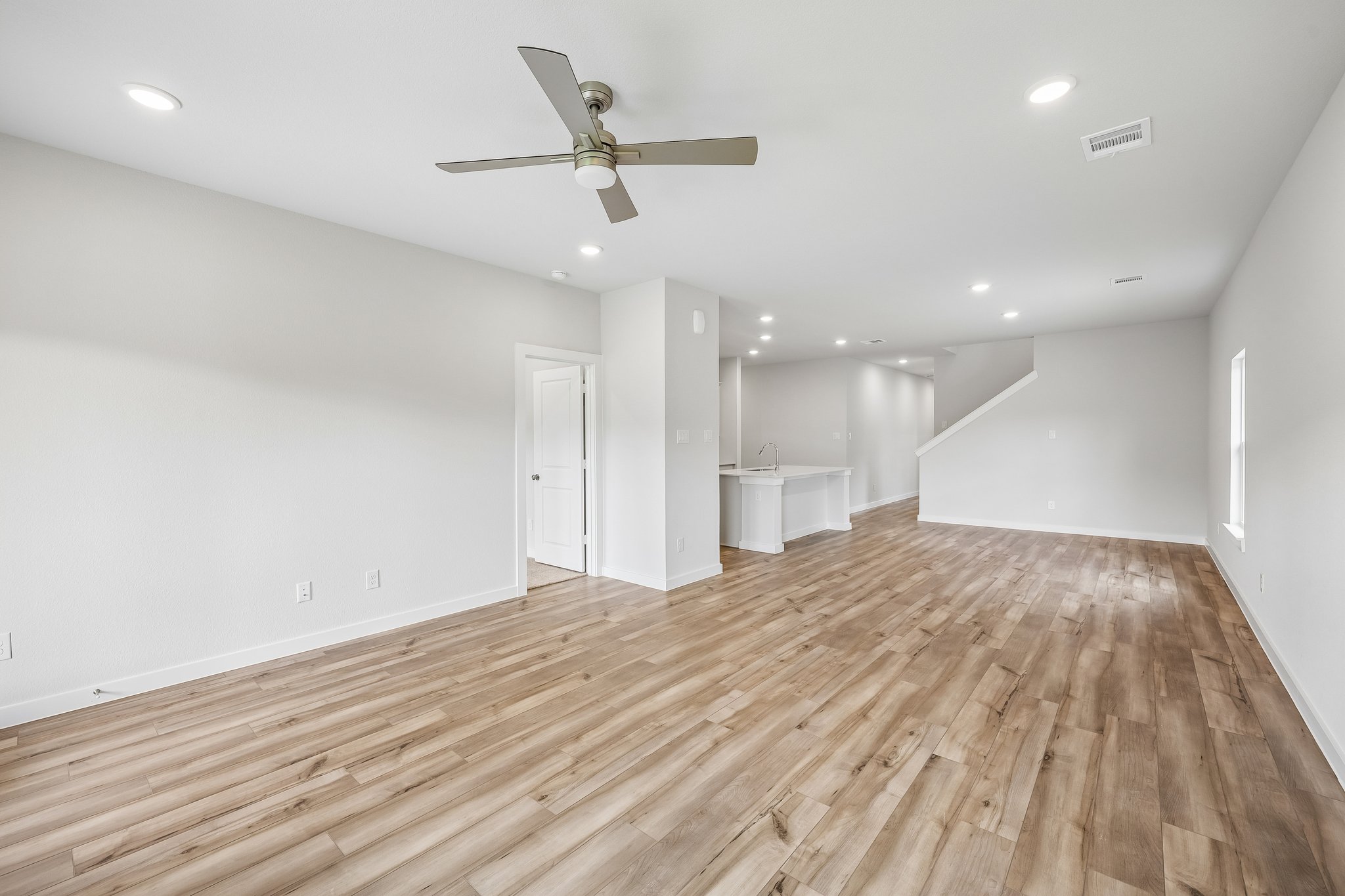 A room with a wood floor and a ceiling fan.
