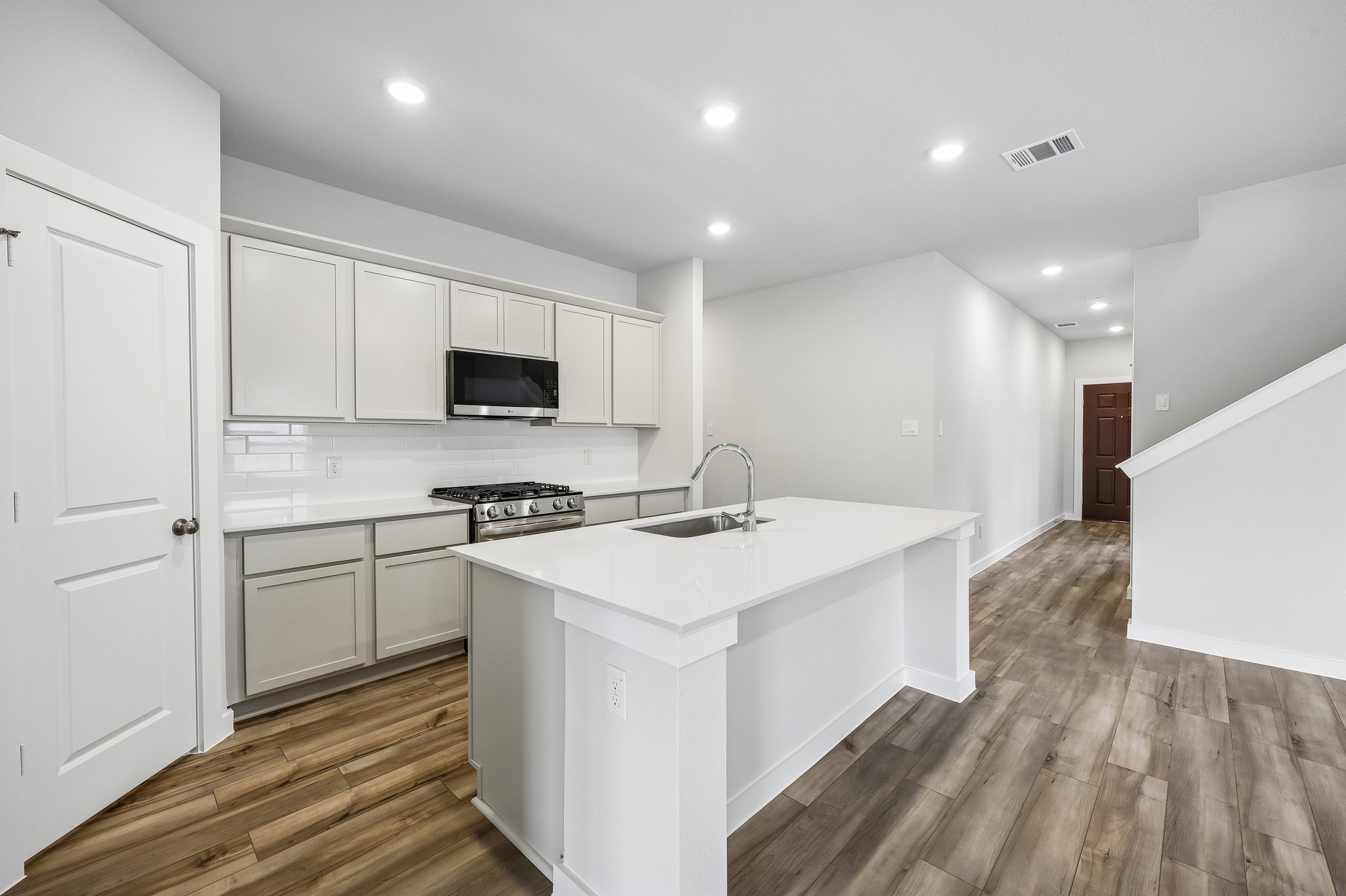 A kitchen with white cabinets.