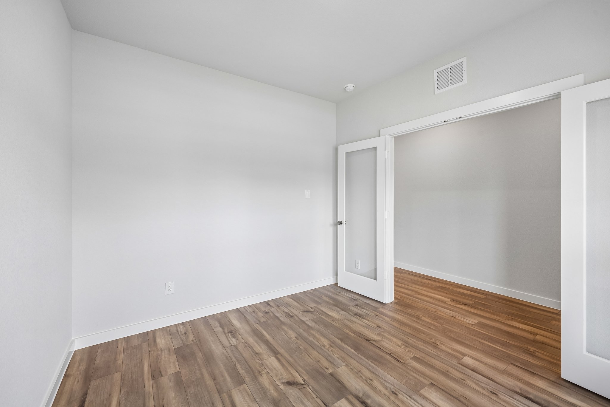 A room with a wood floor and a white door.