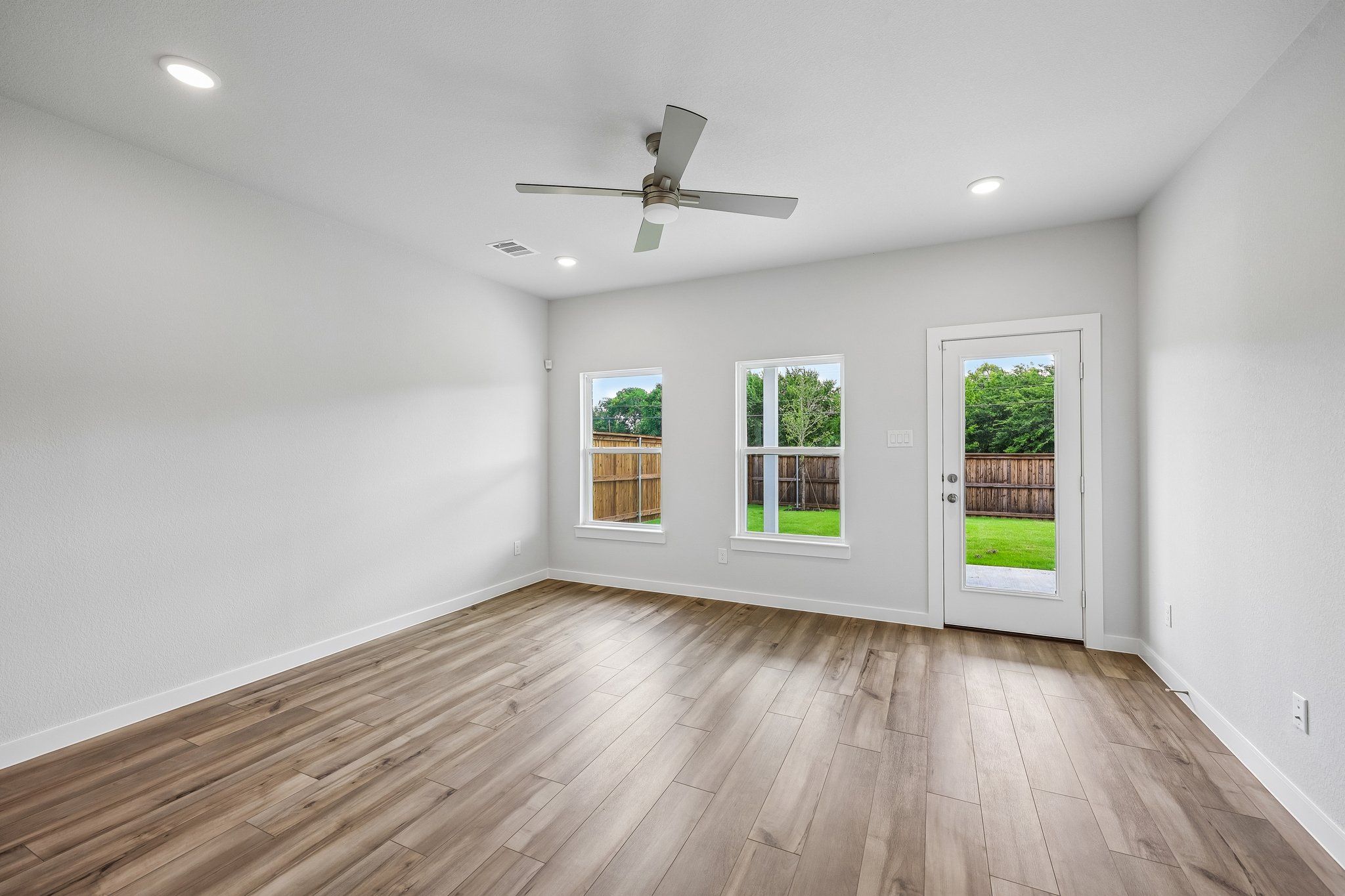 A room with a wood floor and a ceiling fan.