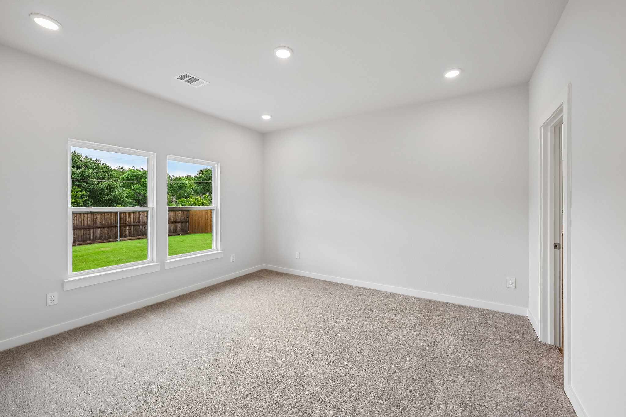 A room with a window and a carpet.