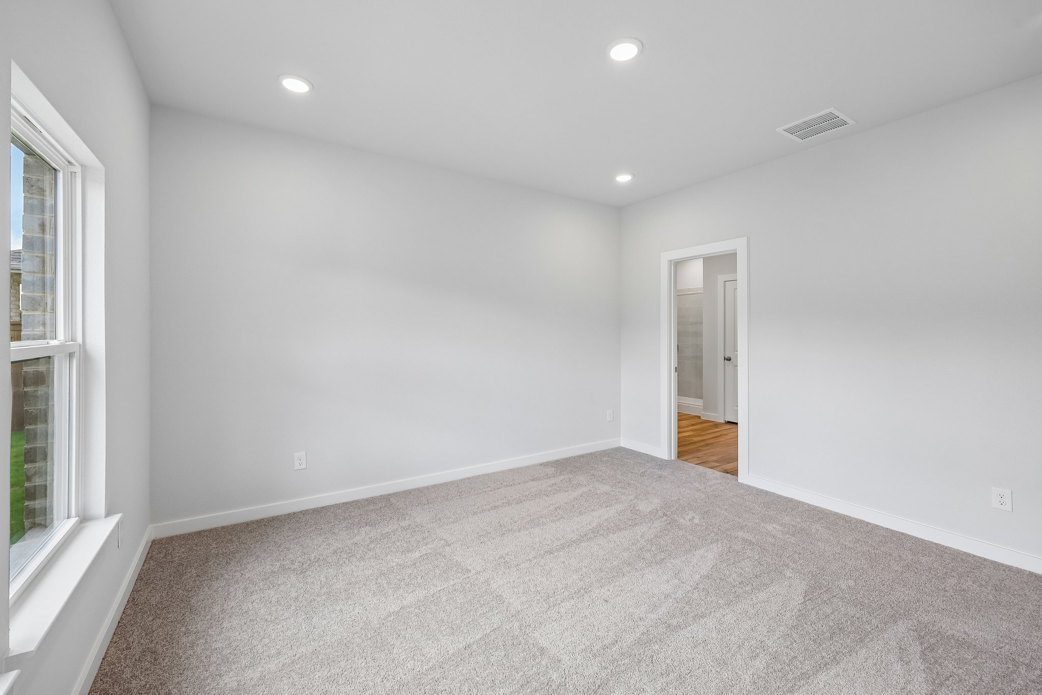 A room with a carpet and a door.
