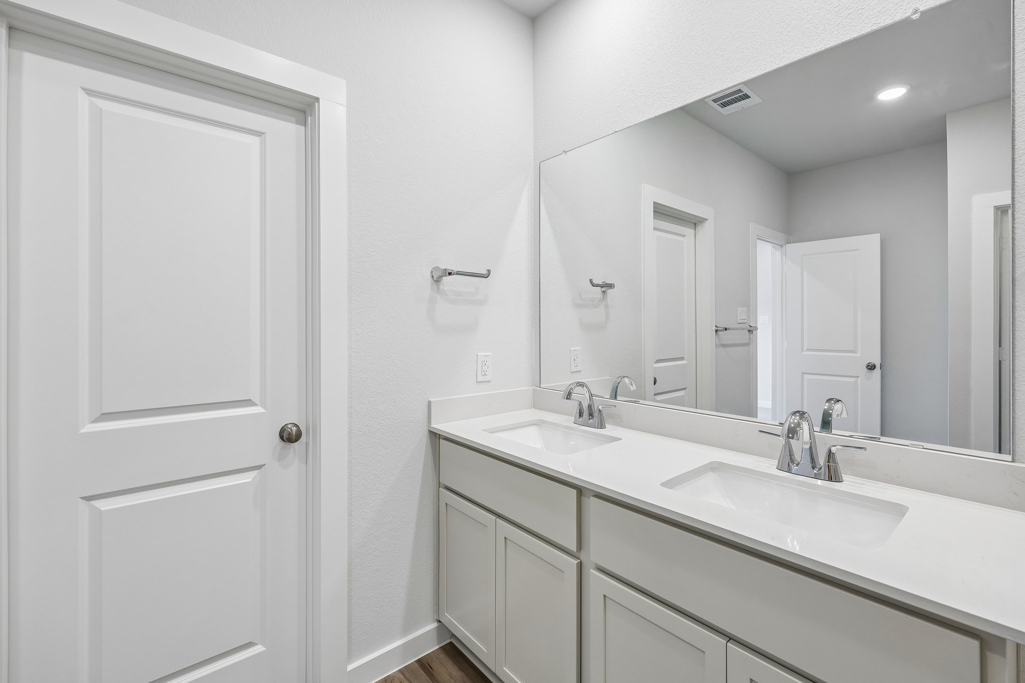 A bathroom with a large mirror.