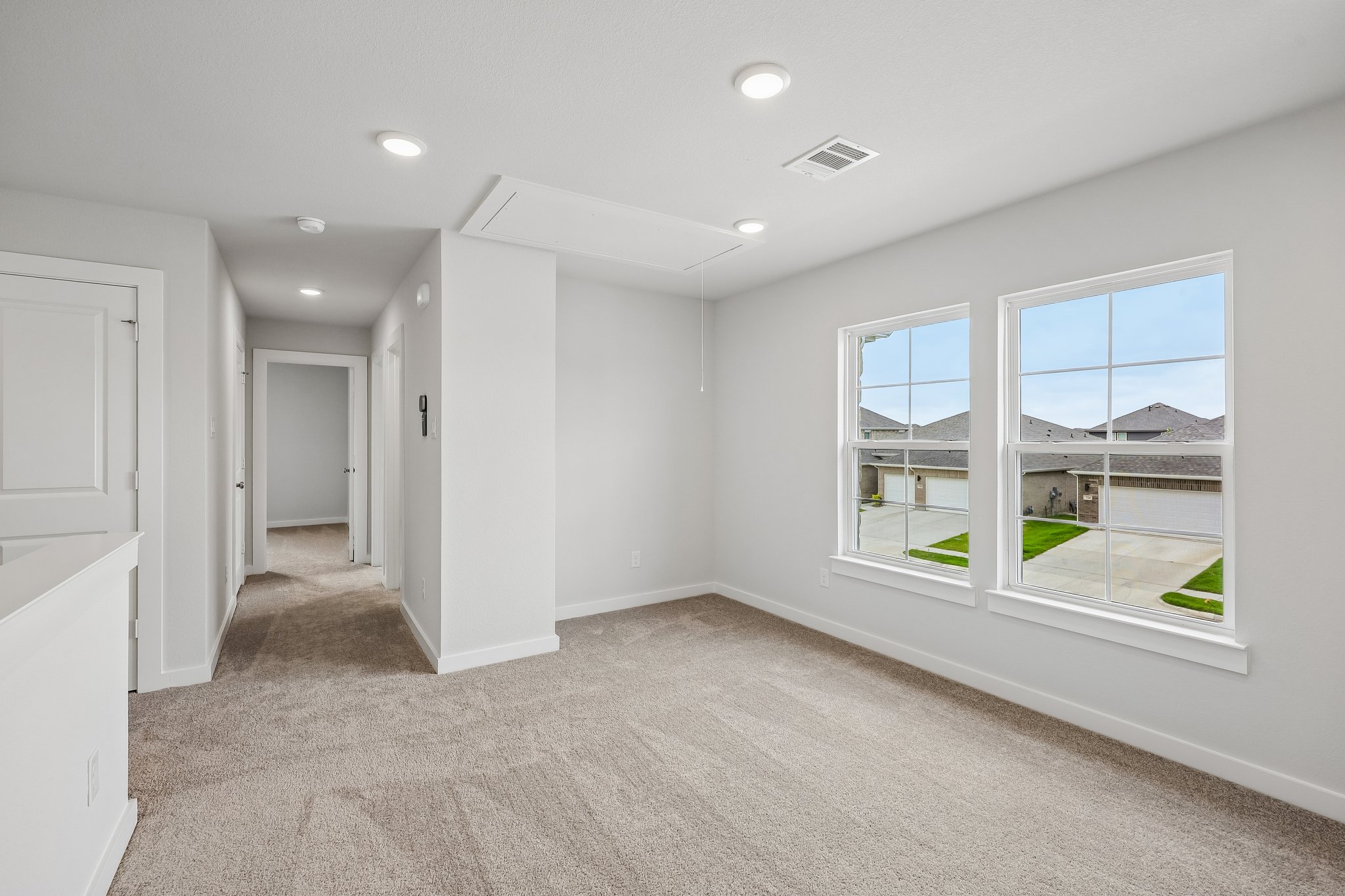 A room with a window and a door with a view of the city.