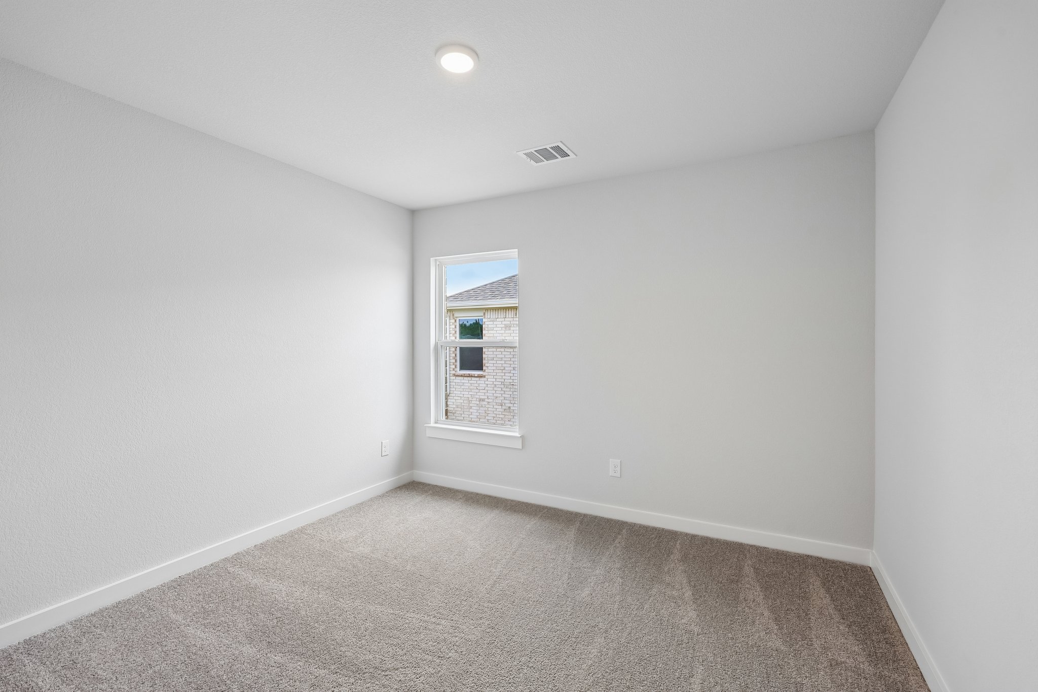 A room with a carpet and a window.