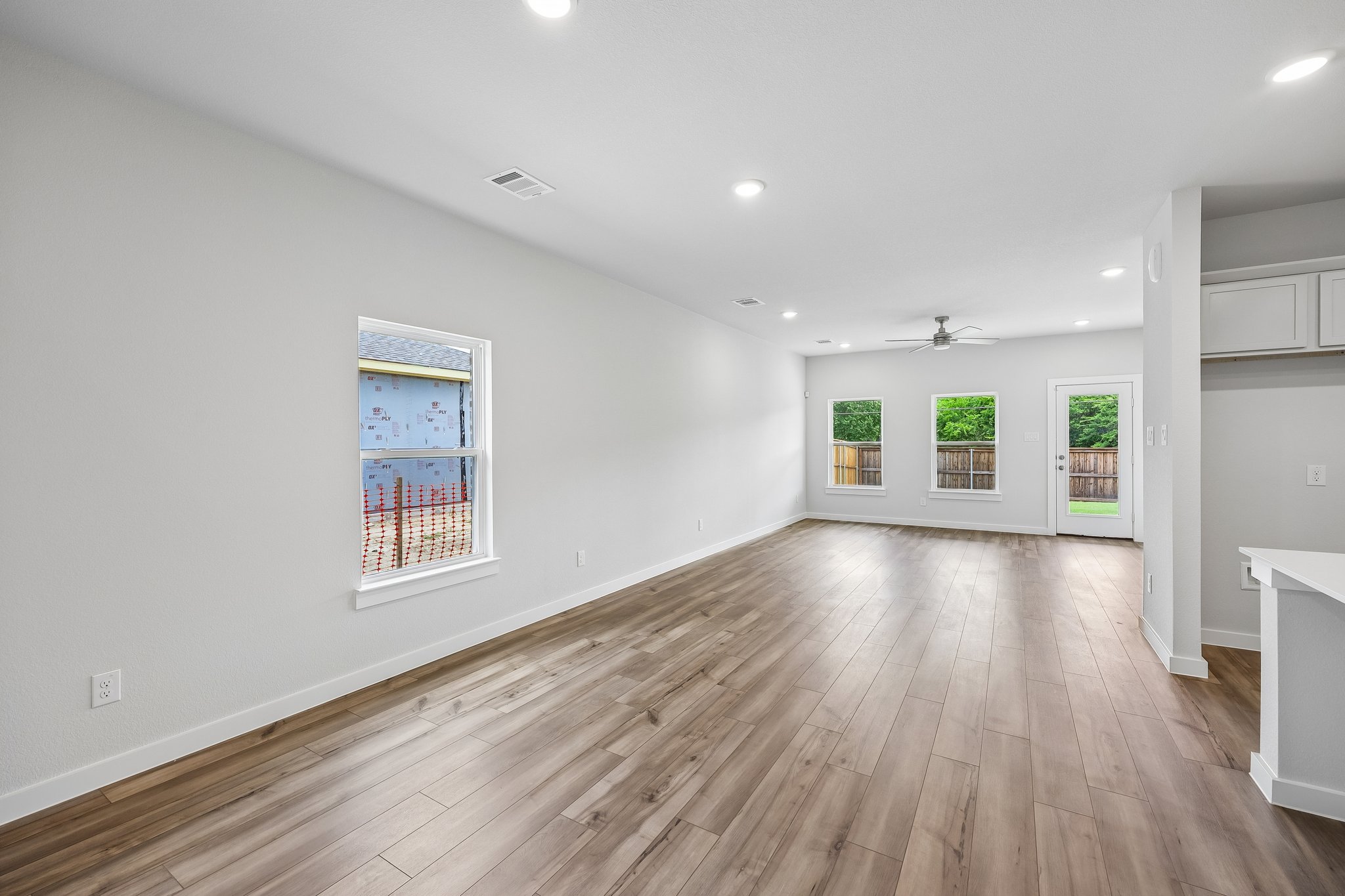 A room with a wood floor and a wood floor with a window.