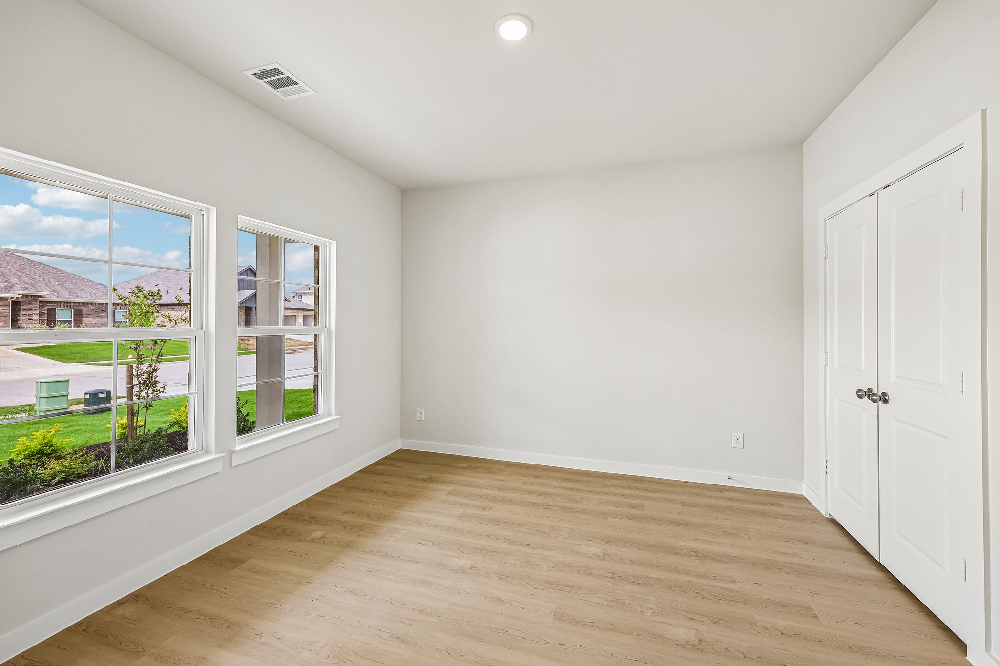 A room with a wood floor and windows.