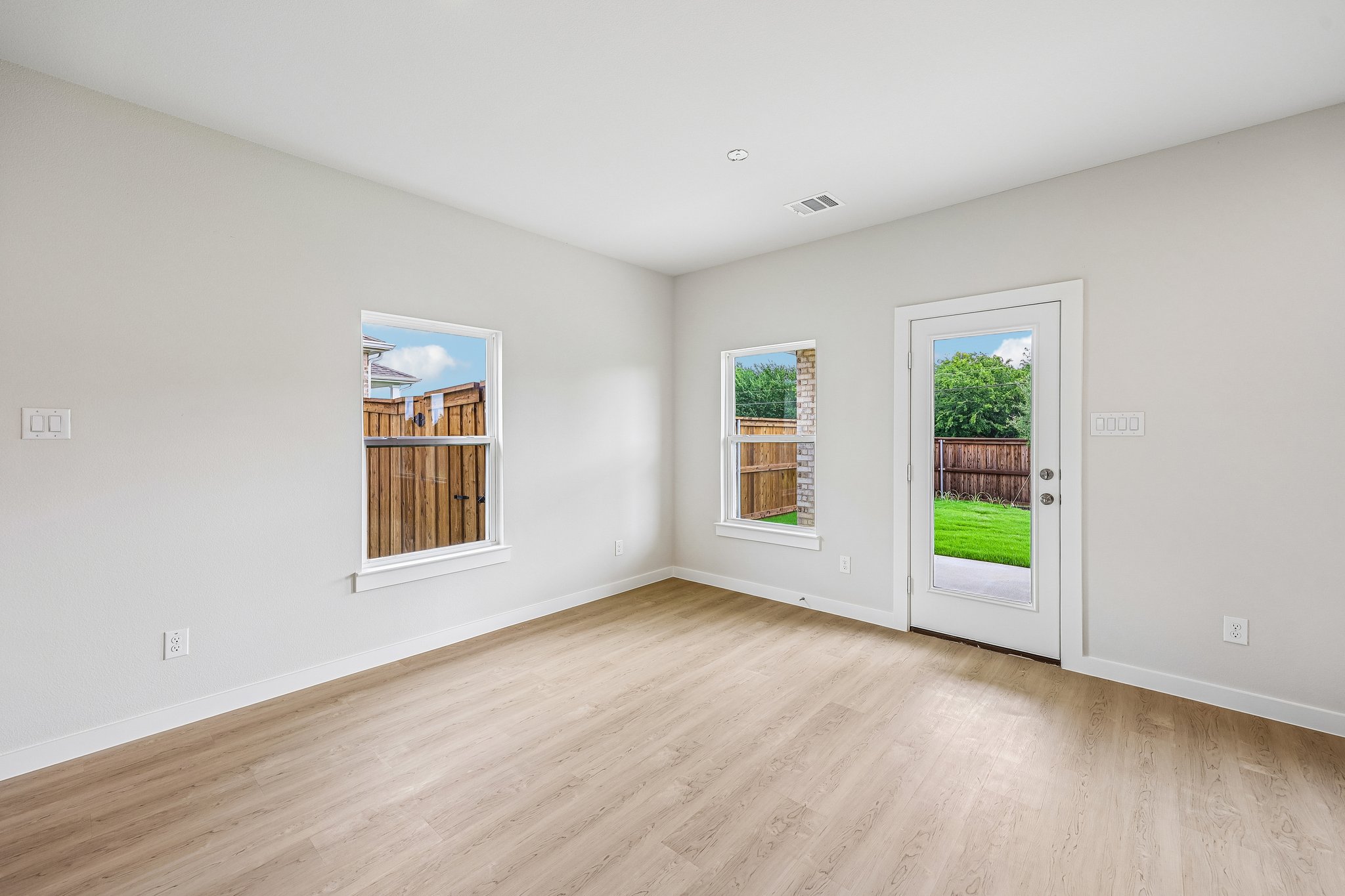 A room with a wood floor and a wood floor with a window.