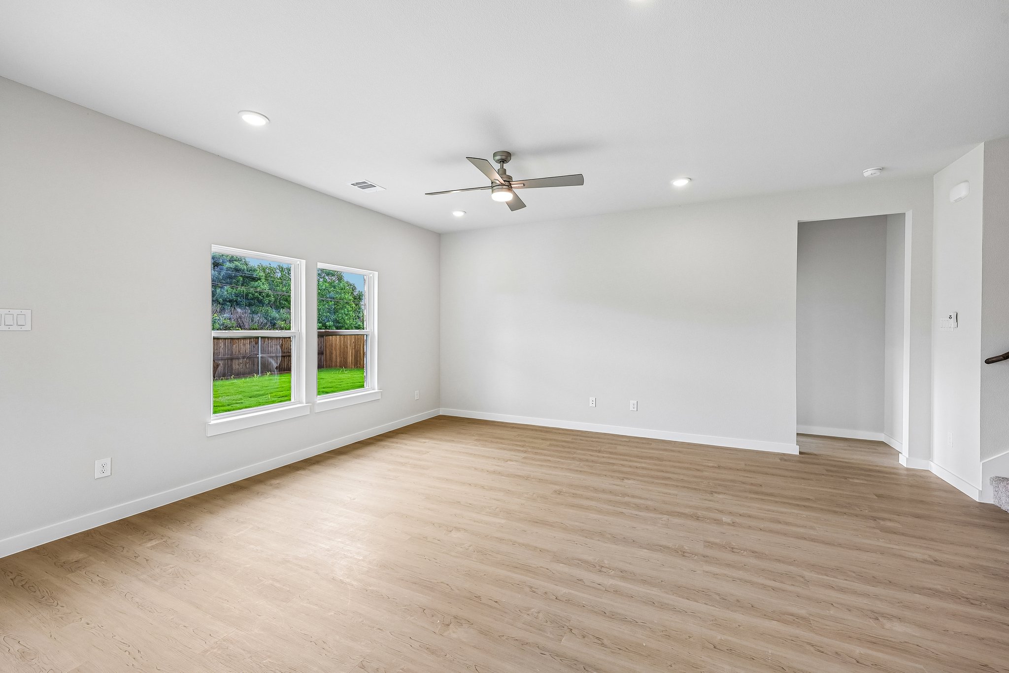 A room with a wood floor and a ceiling fan.
