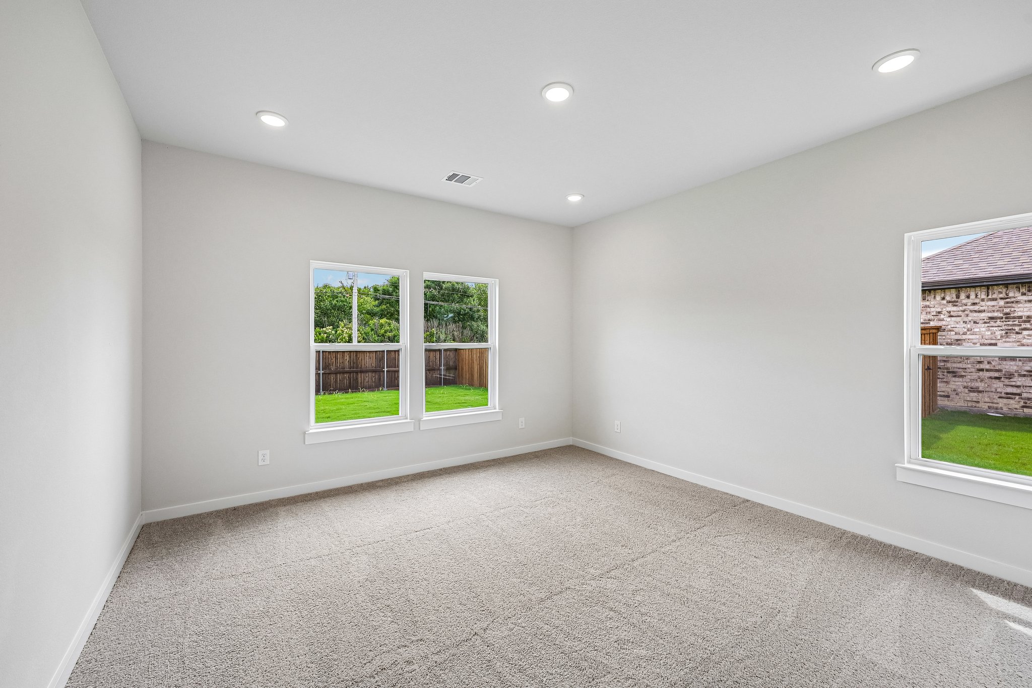 A room with windows and a carpet.