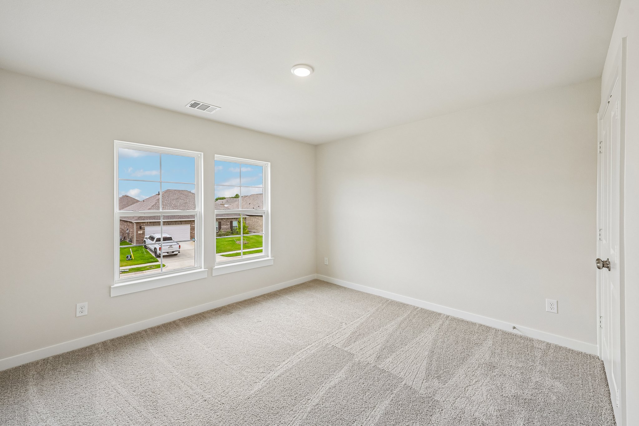 A room with a window and a carpet.