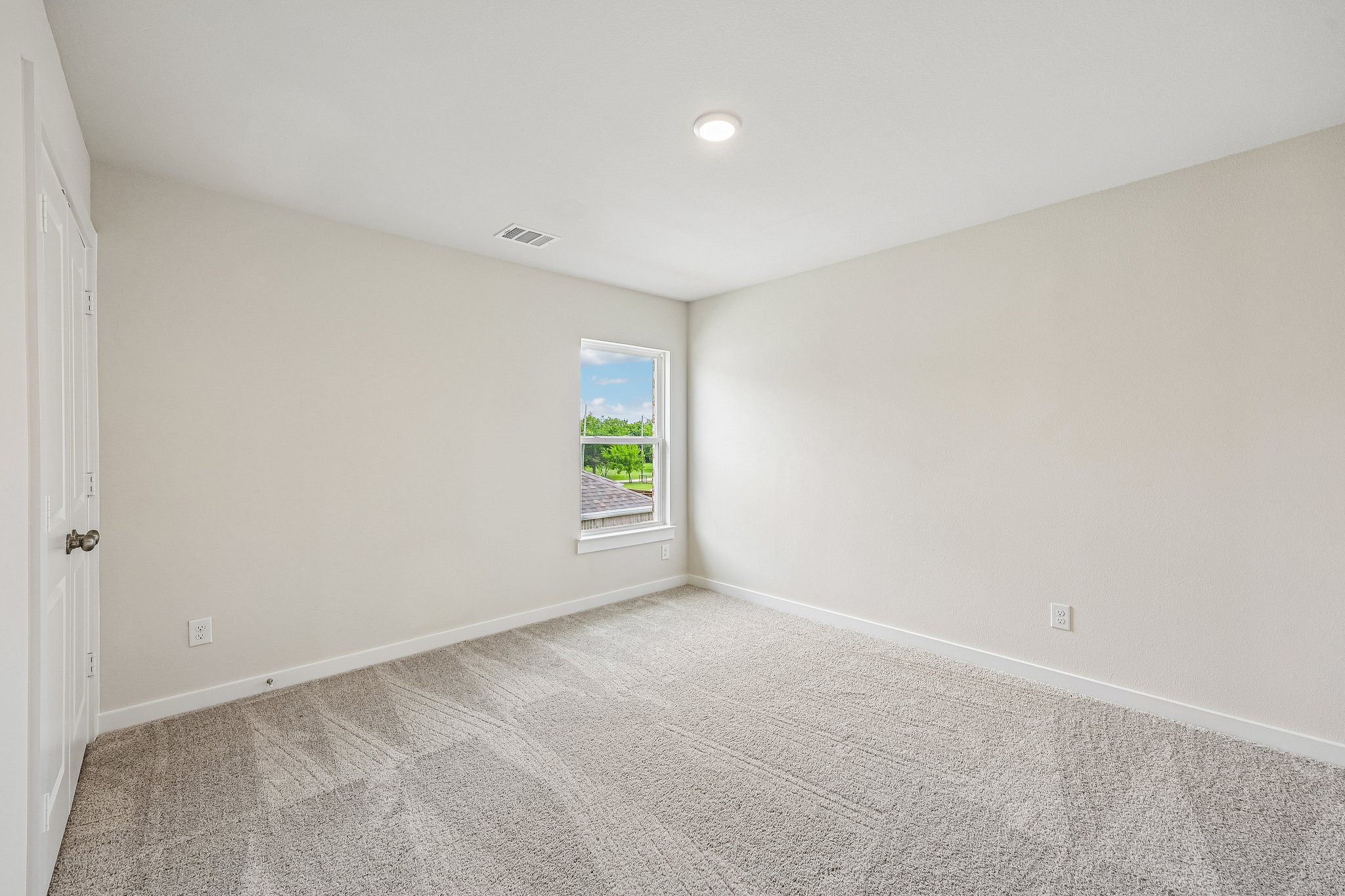 A room with a carpet and a window.