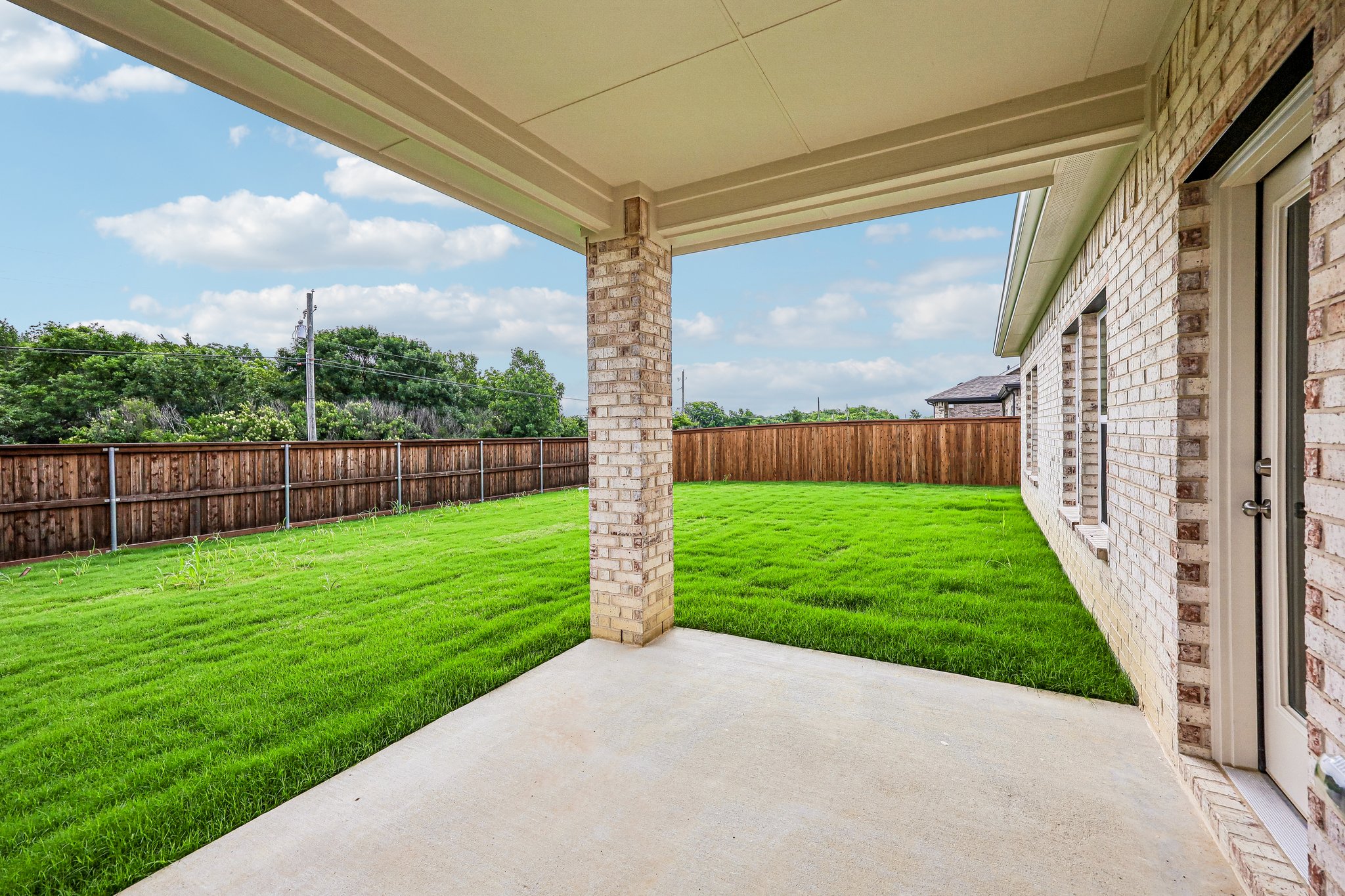 A walkway with grass and a fence.