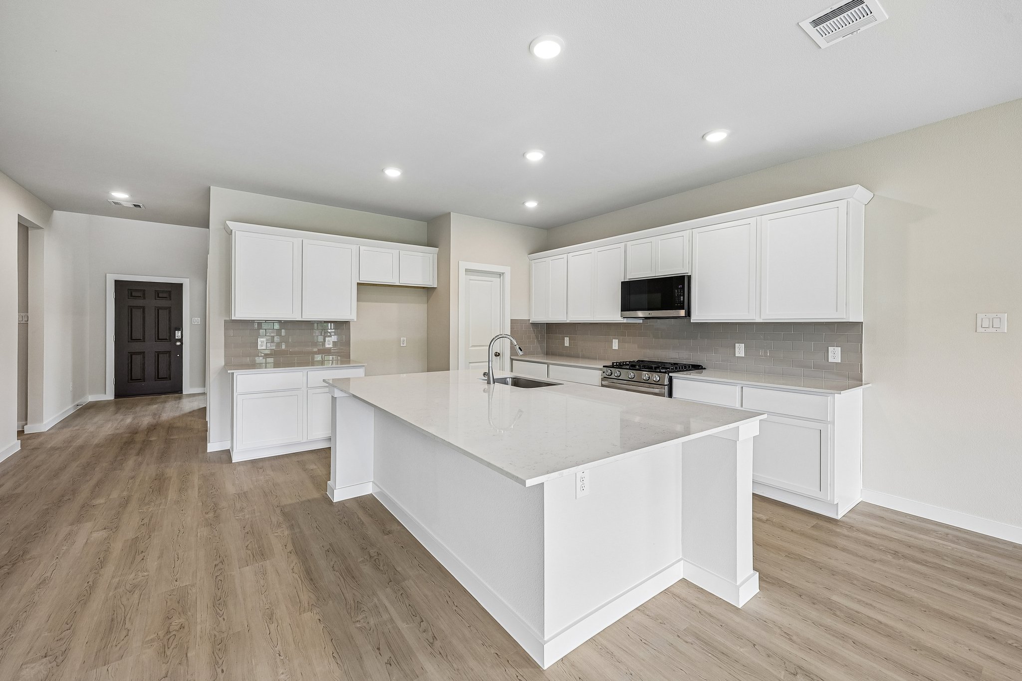 A kitchen with white cabinets.