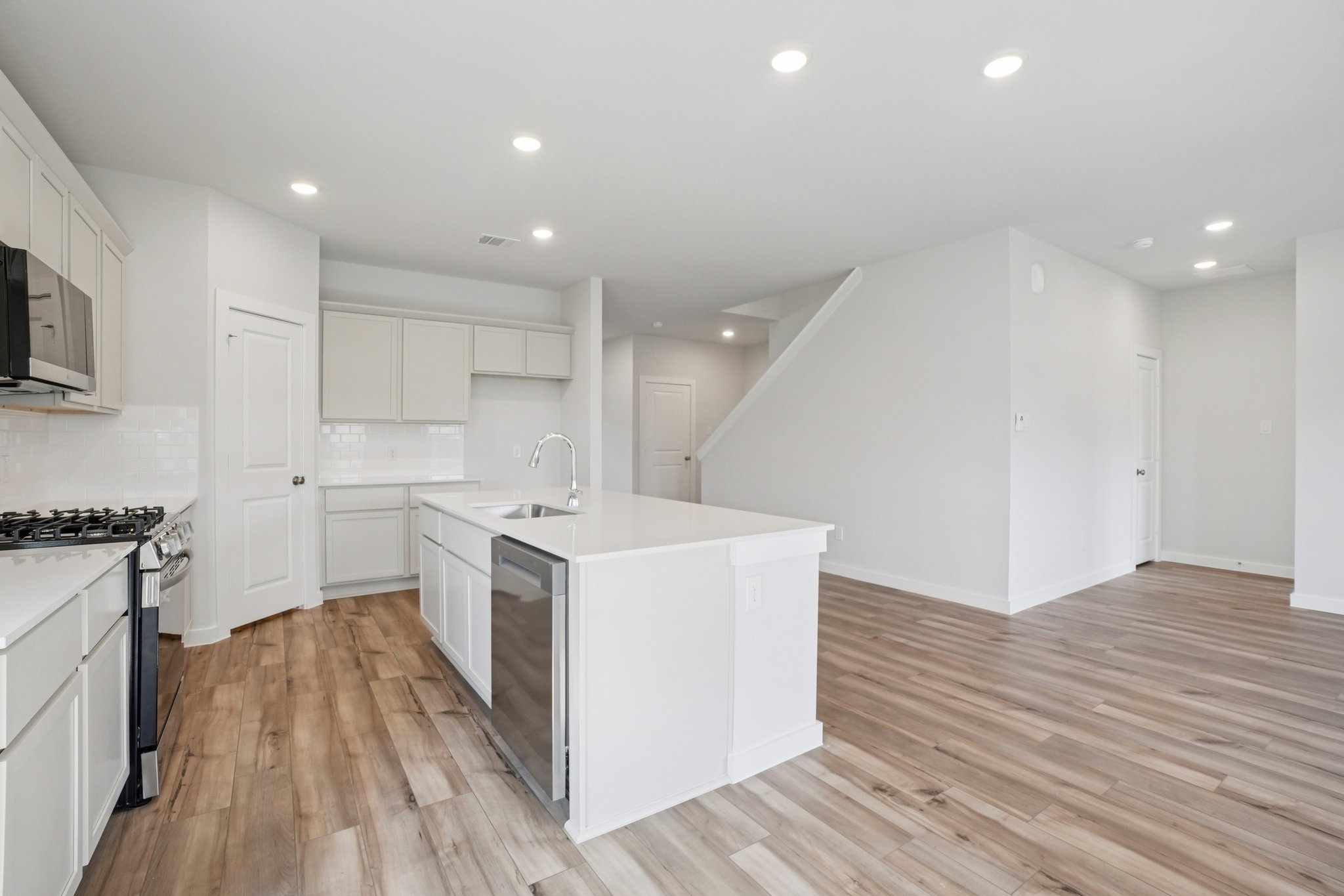 A kitchen with white cabinets.